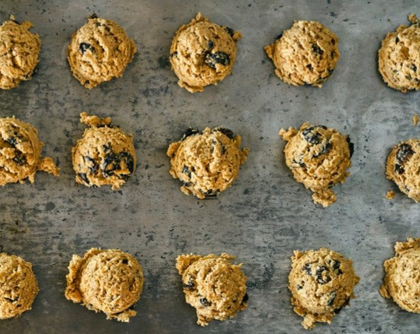 step 9 Using an ice cream scoop, scoop the batter and place 6 cookies on a tray. You will have to cook them in batches. Smash down each cookie with your middle 3 fingers so they are 1/2-3/4 inch thick.