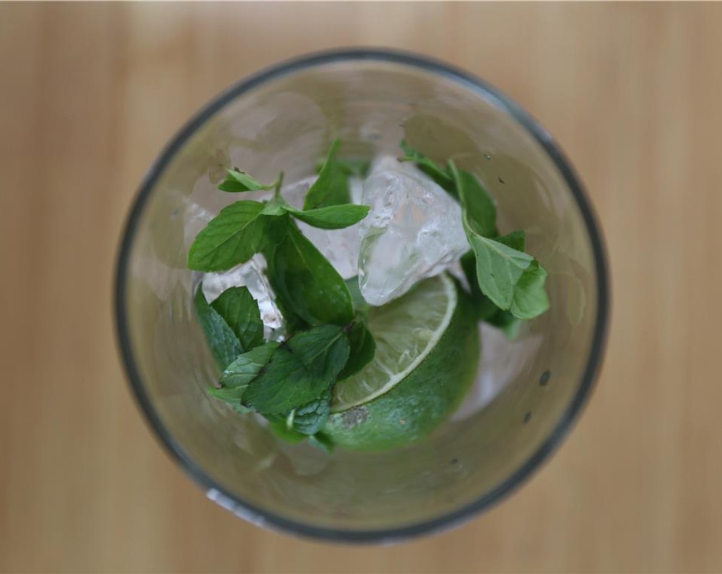 step 1 Cut the Lime (1) into wedges. In a pint glass, muddle a bit of Ice (to taste), Fresh Mint (to taste), and a lime wedge.