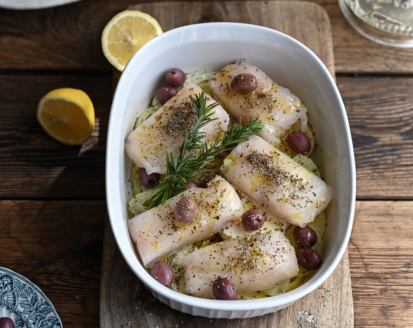 step 5 Juice the remaining Lemon (1/2) and add to the dish. Season the hake with the Dried Oregano (3 tsp) and Smoked Paprika (2 tsp) and tuck the Fresh Rosemary (2 sprigs) in amongst the fish.