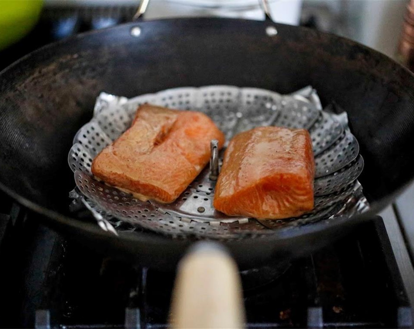 step 12 Take salmon out of the marinade, blotting the bottom side of the salmon only, on a paper towel, then place salmon on the vegetable steam, so they are not touching each other or the edges of the wok.