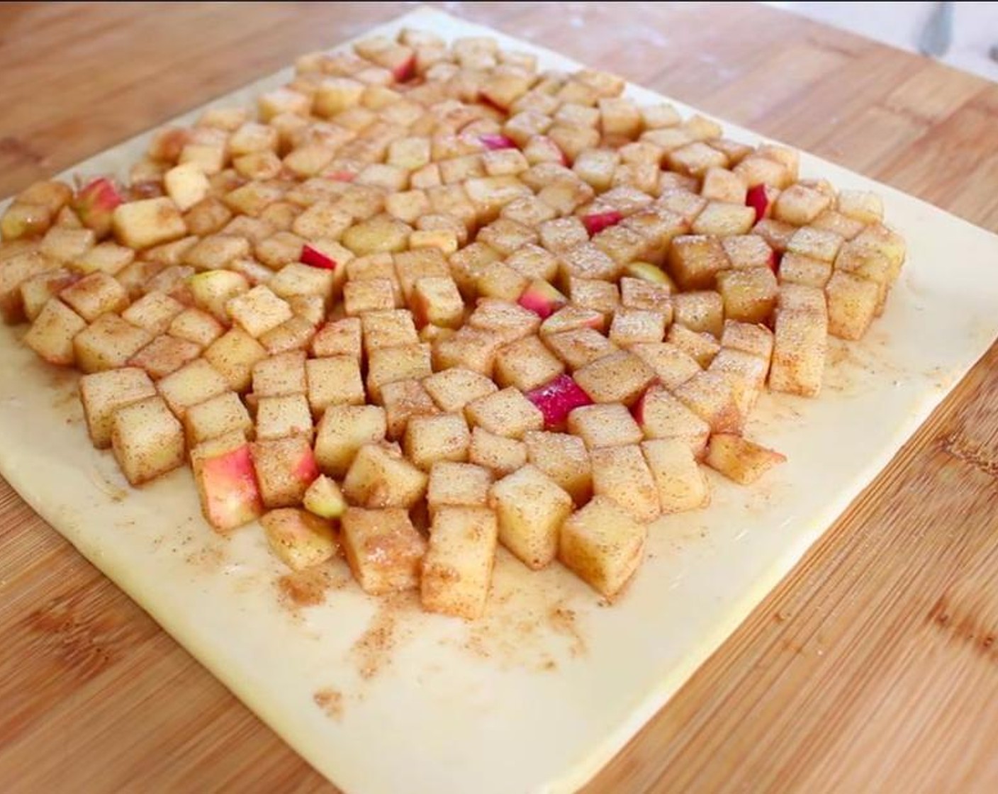 step 3 Place the Puff Pastry (2 sheets) on a flat working surface or roll out pastry until thin if using homemade. Spread the apples over evenly making sure you don't make a double layer.