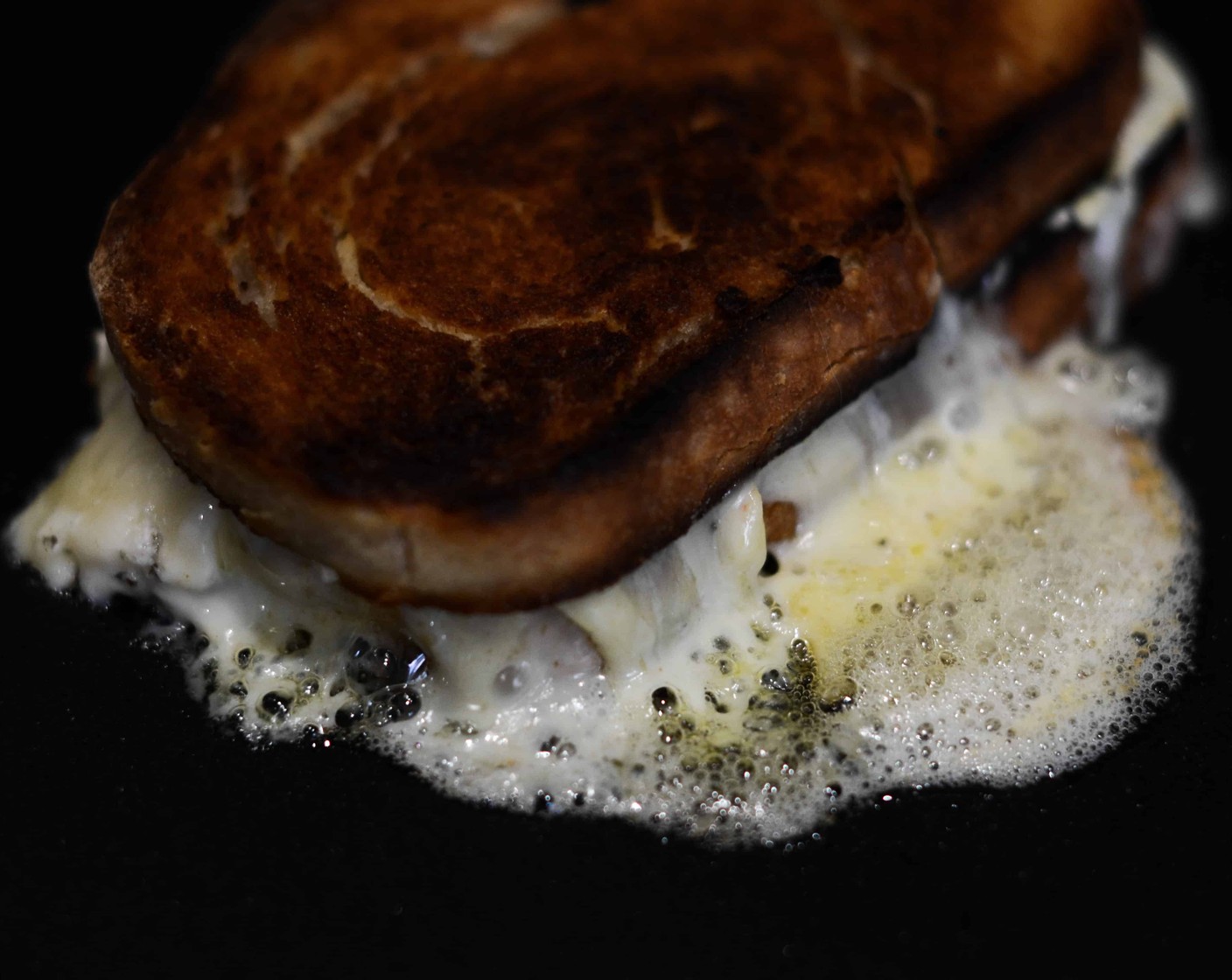 step 8 Top with the second slice – butter side out – and place on a flat-top toaster, pressing to flatten. A pan works just as well but make sure to flatten your sandwich with a plate weighed down with tinned food, turning once golden.