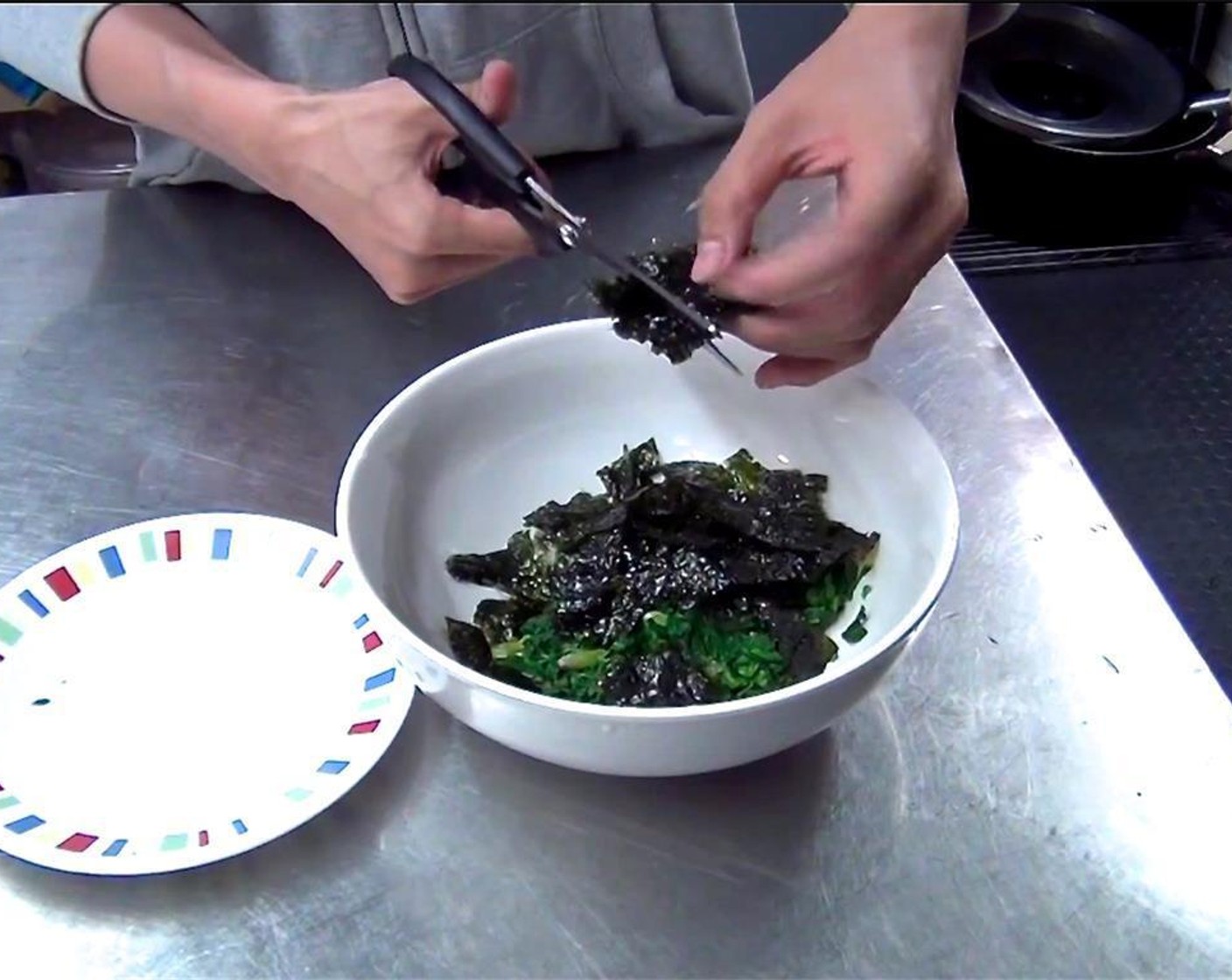 step 4 Use kitchen shears to cut the layer of Dried Seaweed (1 sheet) on top of the chopped spinach.
