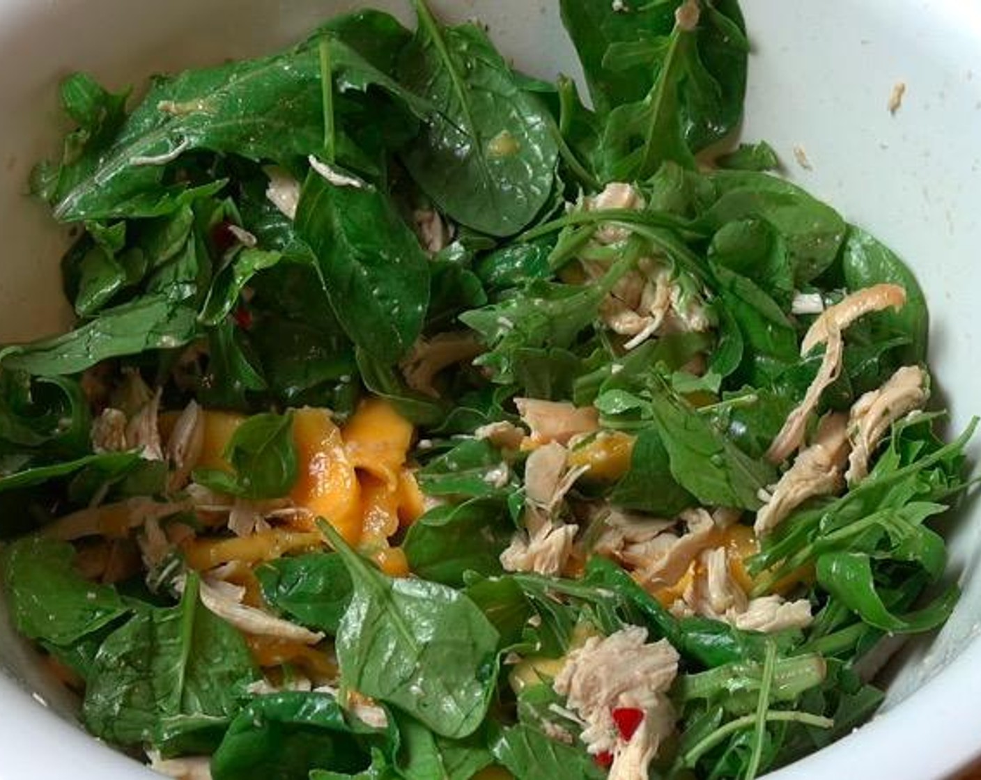 step 2 In a large mixing bowl, add Salad Greens (1 1/3 cups), Chicken Breasts (2 cups) and Mangoes (2). Drizzle dressing over top. Gently toss everything together to combine and season with Freshly Ground Black Pepper (to taste).