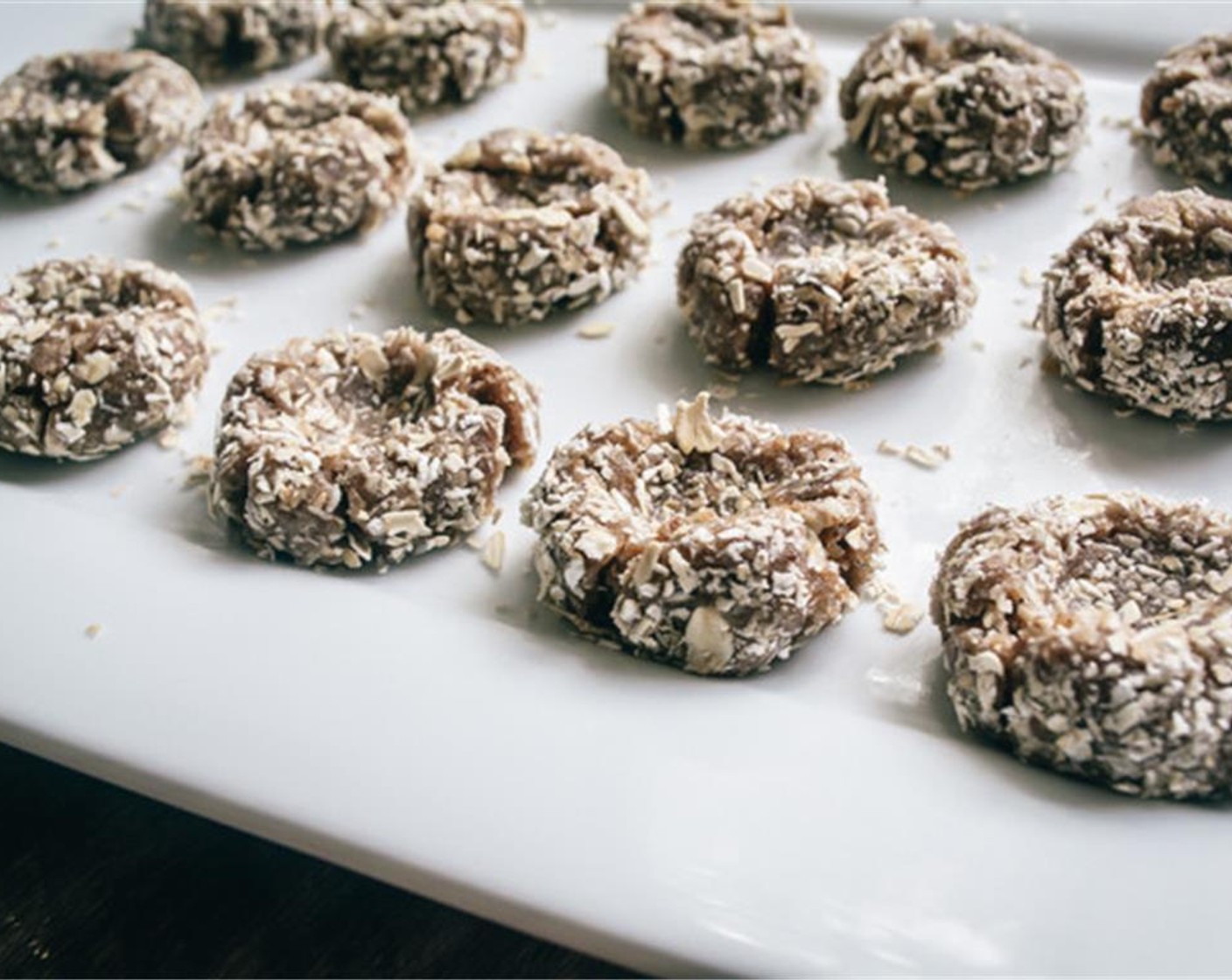 step 4 Roll each cookie ball in chopped oats and return to wax lined baking sheet. Use thumb to press in center, leaving an indention for the caramel filling.