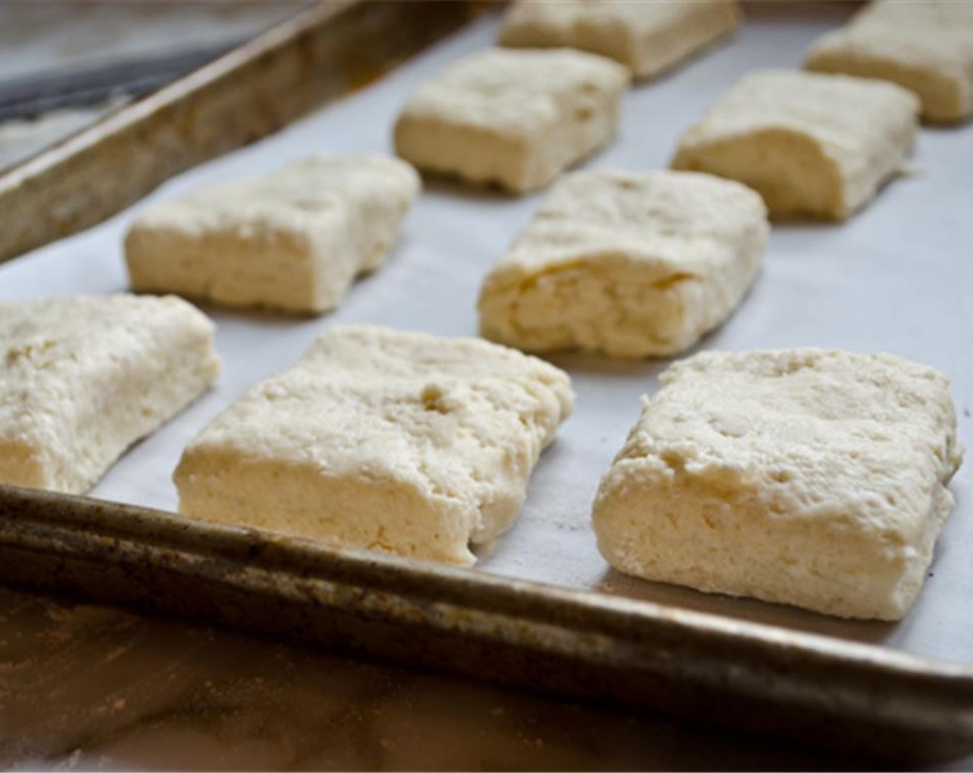 step 8 Dust the blade of a sharp knife with flour and cut the dough into twelve even squares. Transfer to the prepared baking sheet and bake for 12 to 15 minutes, until the biscuits are lightly golden on top and a deeper brown on the bottoms.