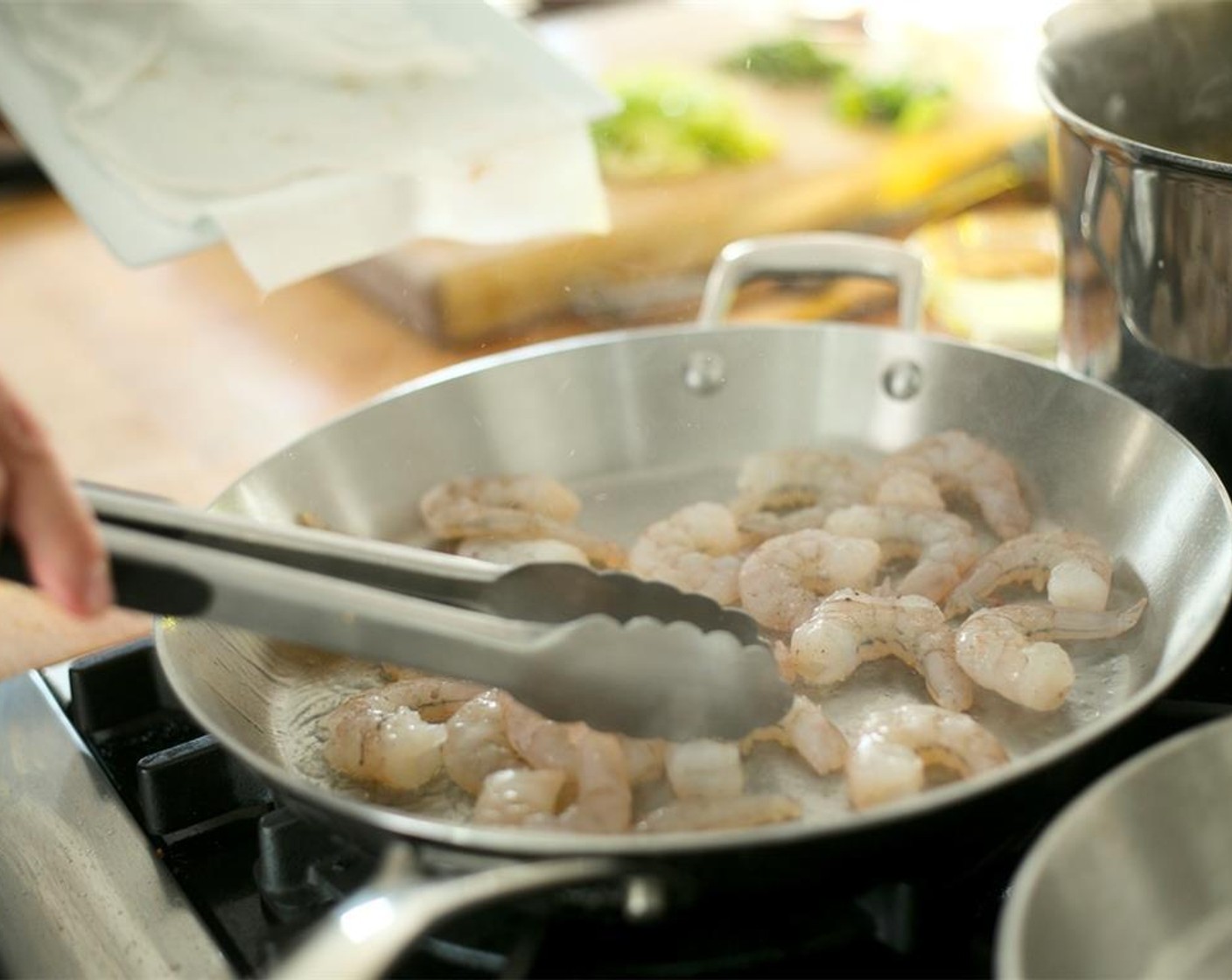 step 8 Carefully add the shrimp to the pan in a single layer. Cook for one minute on both sides and remove shrimp from pan to a plate. Keep warm.