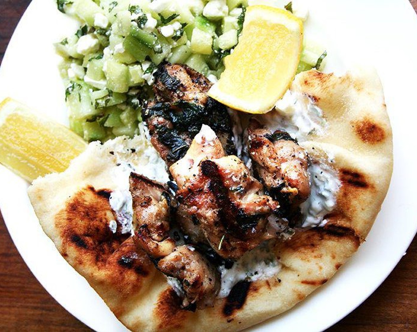 step 8 Serve chicken with tzatziki, a wedge of Lemon (1) and grilled naan. Enjoy!