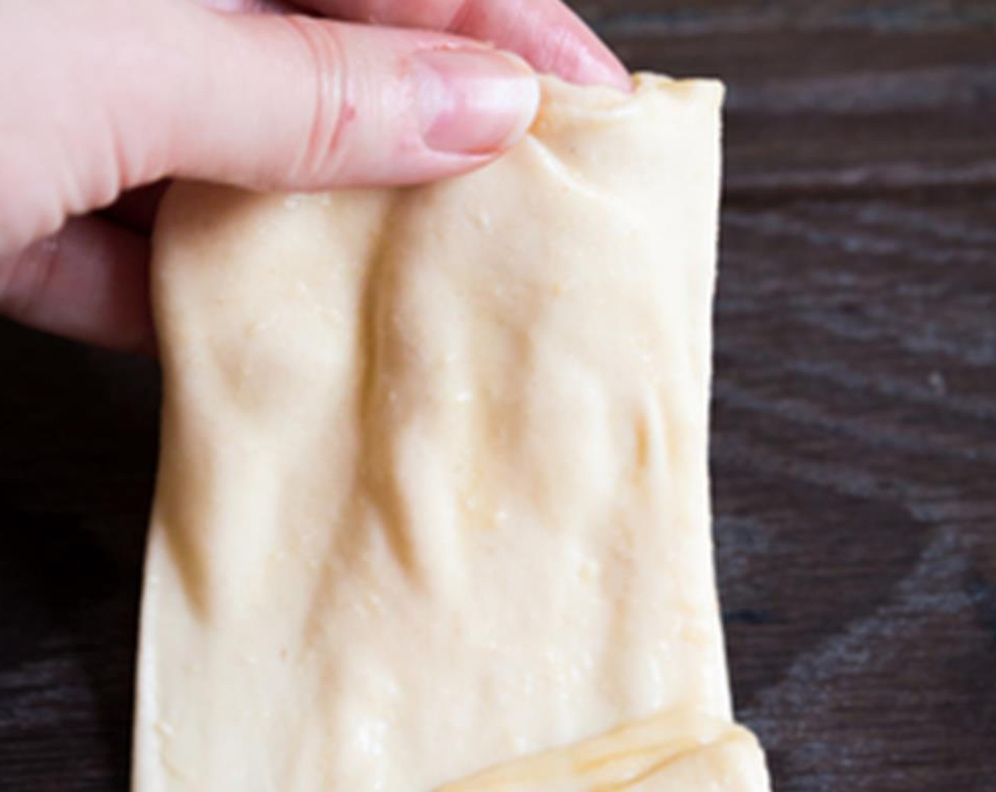 step 6 Fold each side of the dough vertically and then horizontally towards the center to make a square. Place the folded msemen on a greased surface and cover with a cloth or a cling film. Repeat the same process until you have folded all the dough balls.