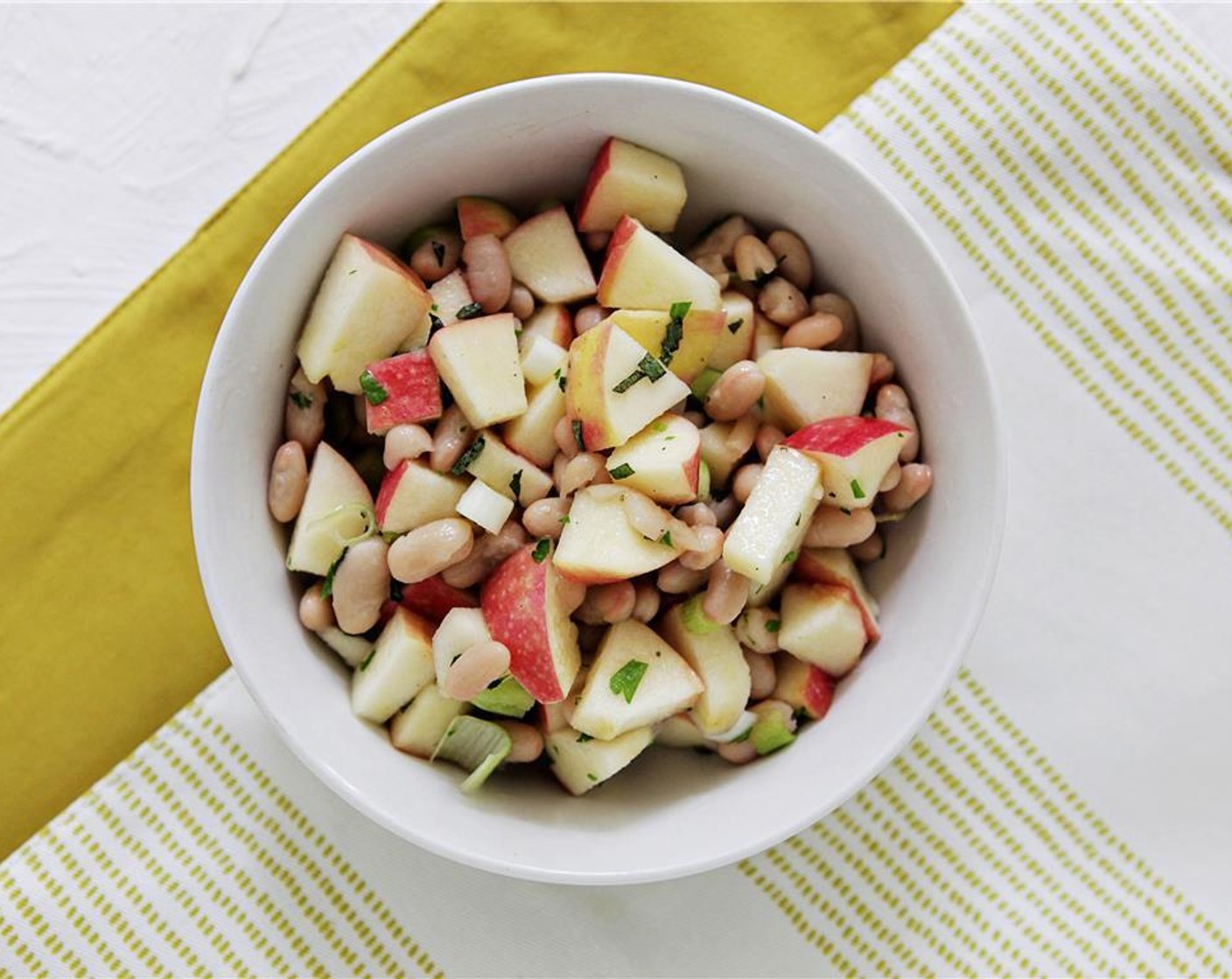 step 4 Combine the white of the scallions, Canned White Beans (1/2 cup), red apples, Apple Cider Vinegar (1 tsp), sage, parsley, and Olive Oil (1 tsp). Stir well, and season to taste with salt and pepper.