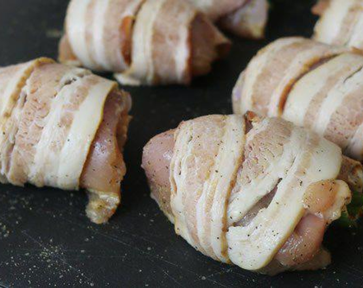 step 3 Place the stuffed pepper cheese side down in the center of each chicken thigh and form the meat around the pepper.  Next wrap each thigh with a strip of Bacon (8 slices).