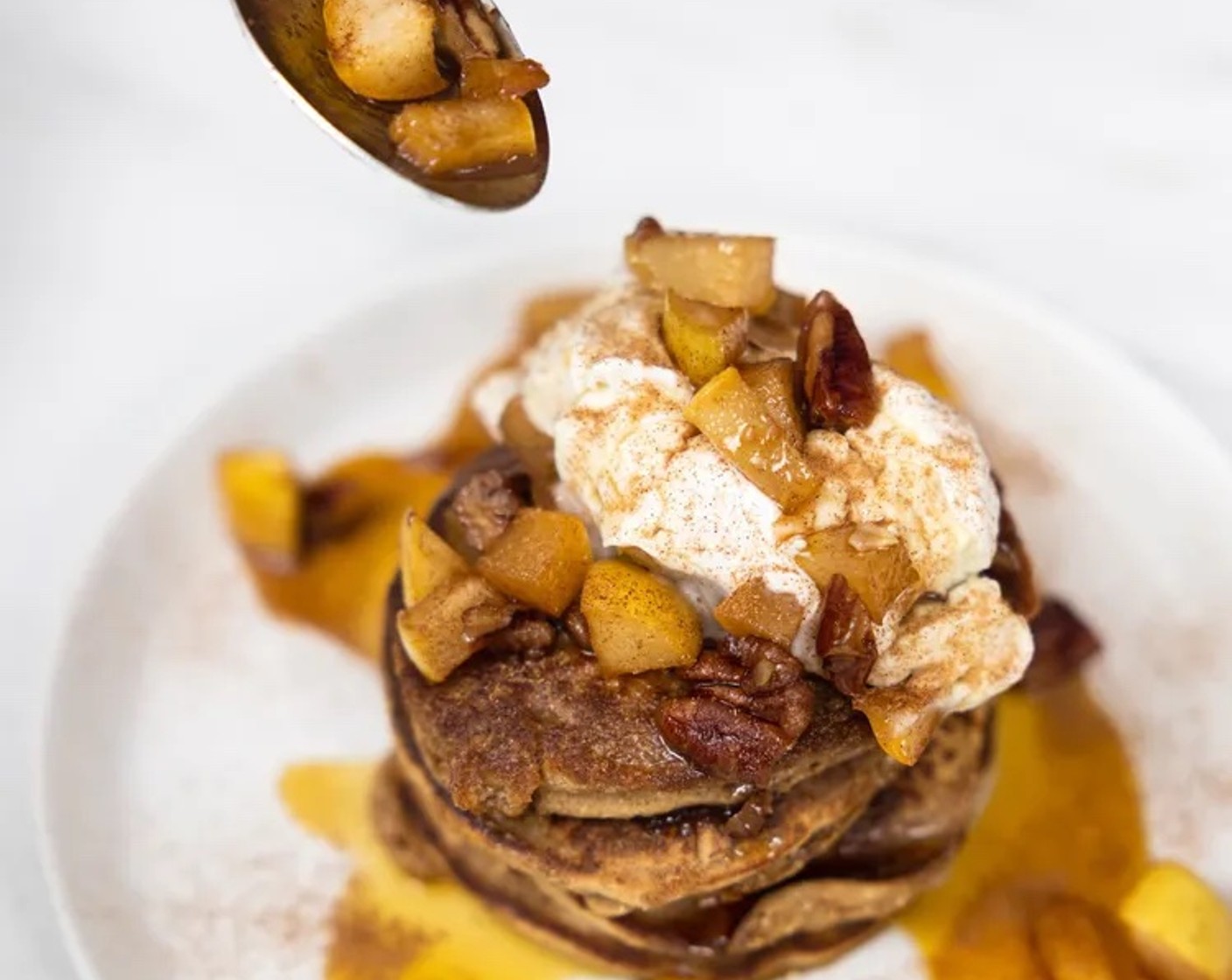 step 8 Assemble pancakes. Place 2 to 3 pancakes on a plate. Add chopped pear walnut mixture, top with coconut whipped cream and maple syrup.