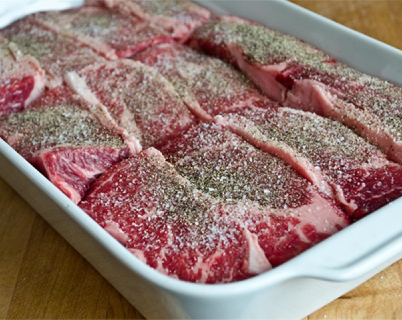 step 2 Cut the Boneless Beef Short Ribs (4 lb) into 4-inch long pieces. Season the ribs all over with Kosher Salt (1/2 Tbsp) and Ground Black Pepper (1 tsp), then arrange in a 13 by 9-inch baking dish.