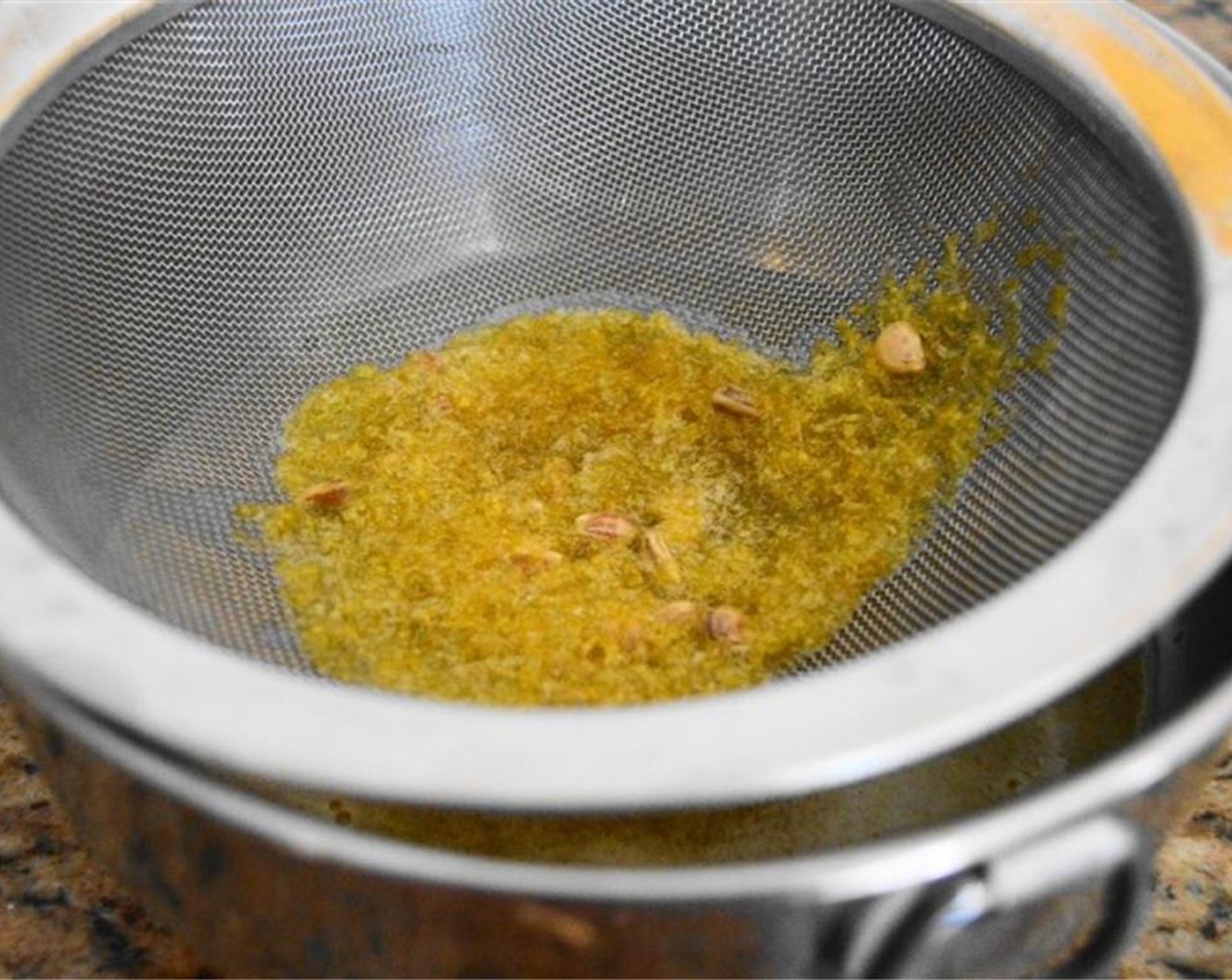 step 3 Take the lemon mixture off of the heat once it starts to gently boil, then pour it through a fine mesh strainer to get rid of the lemon zest and any little particles in the lemon juice.