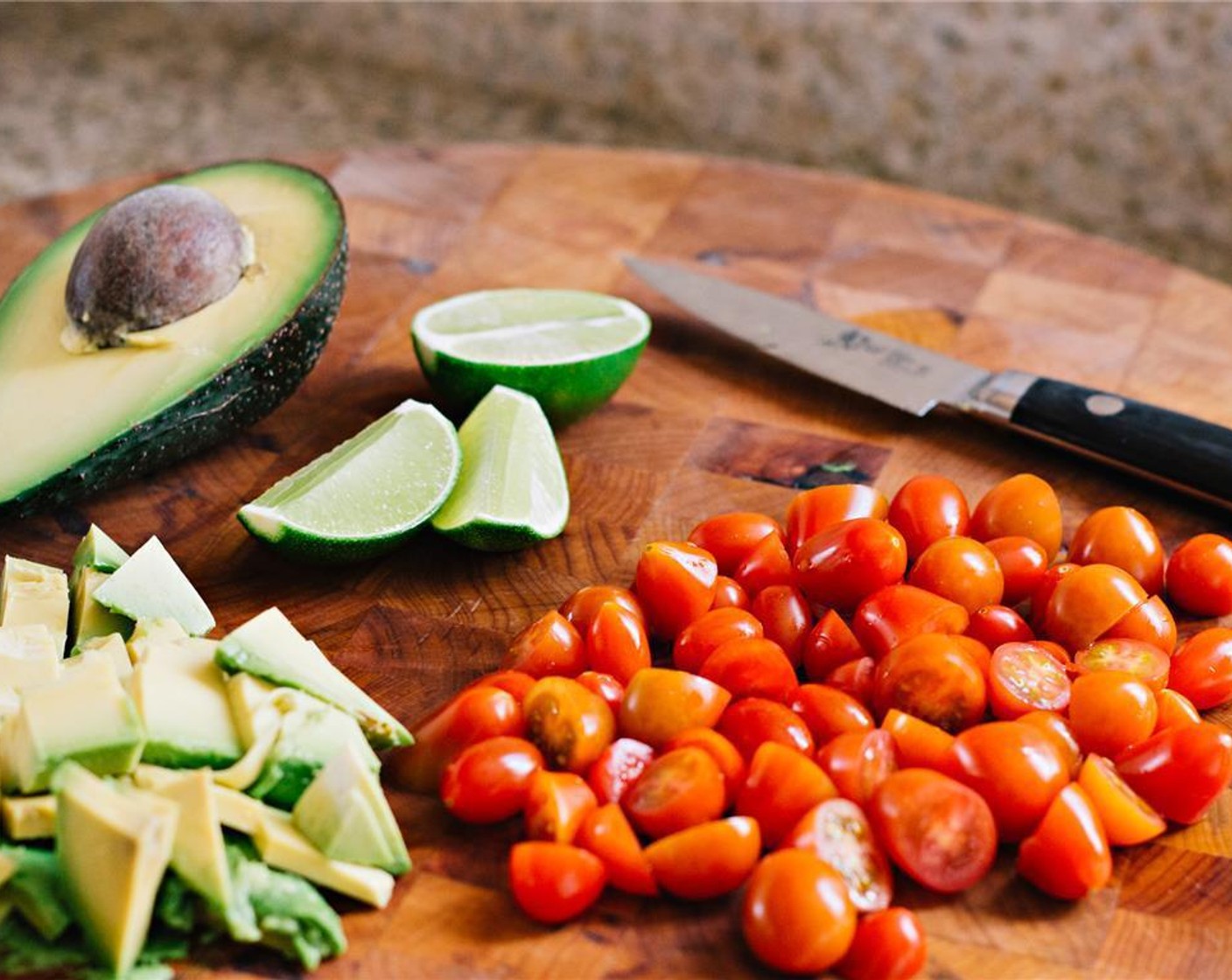 step 5 In der Zwischenzeit die Cherrytomate (3/4 Ta.) halbieren, die Limette (1) in Wedges schneiden und die Avocado (1) würfeln.