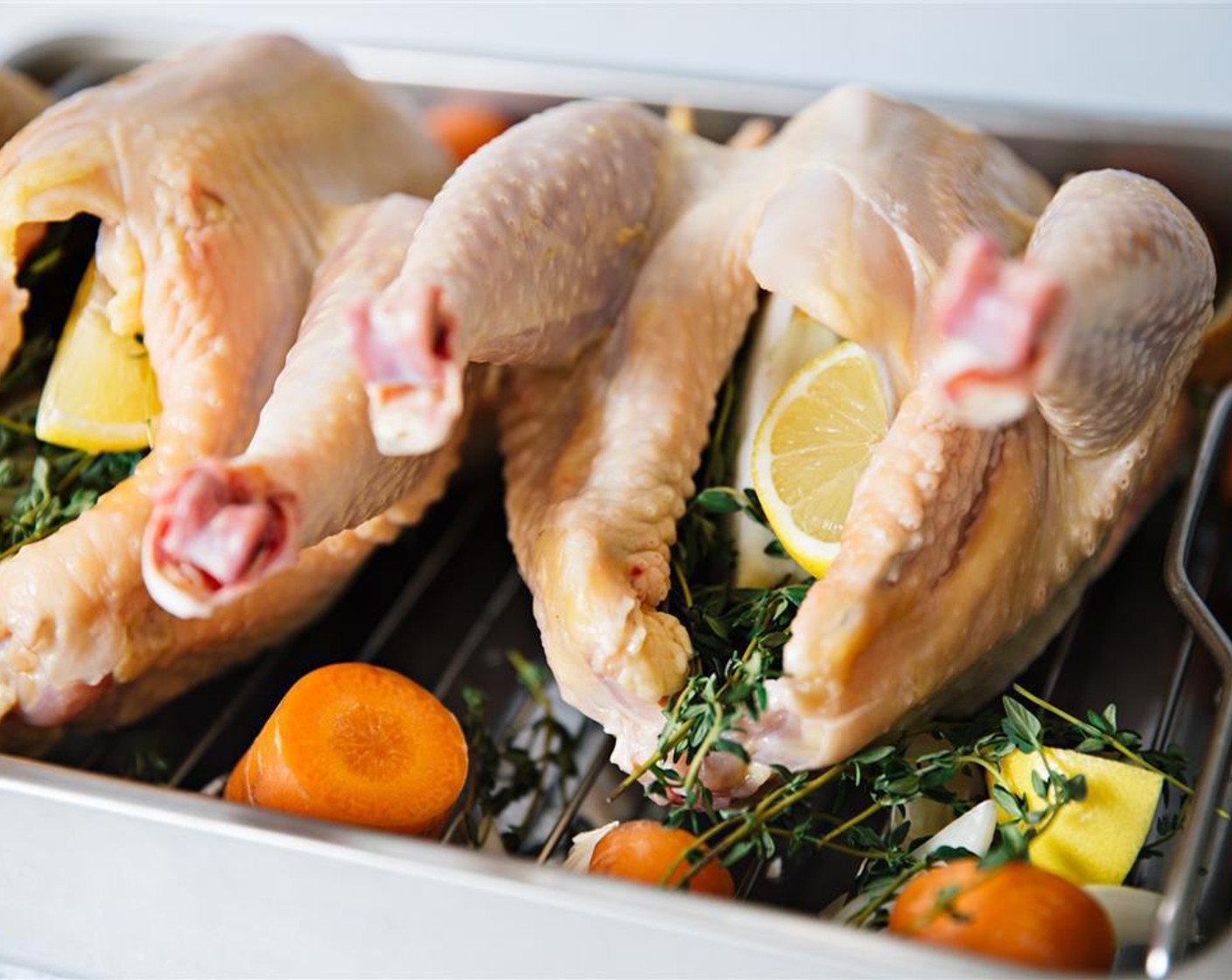 step 6 Stuff inside of Whole Chicken (1) with lemon, large garlic clove, and Fresh Thyme (1 bunch). Scatter carrots and onions on roasting tray around chicken.