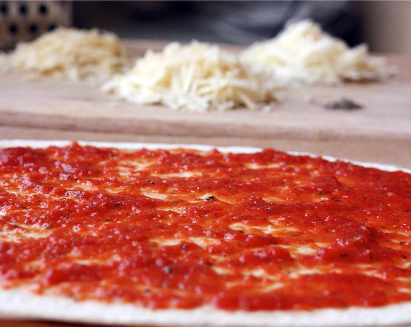 step 5 Once the dough has rested for a few minutes, roll it out on a floured surface until it is about 1/4 inch thick. Sprinkle a cutting board with corn meal or flour and transfer the crust to the board. Then spread Pizza Sauce (3/4 cup) evenly on the dough.