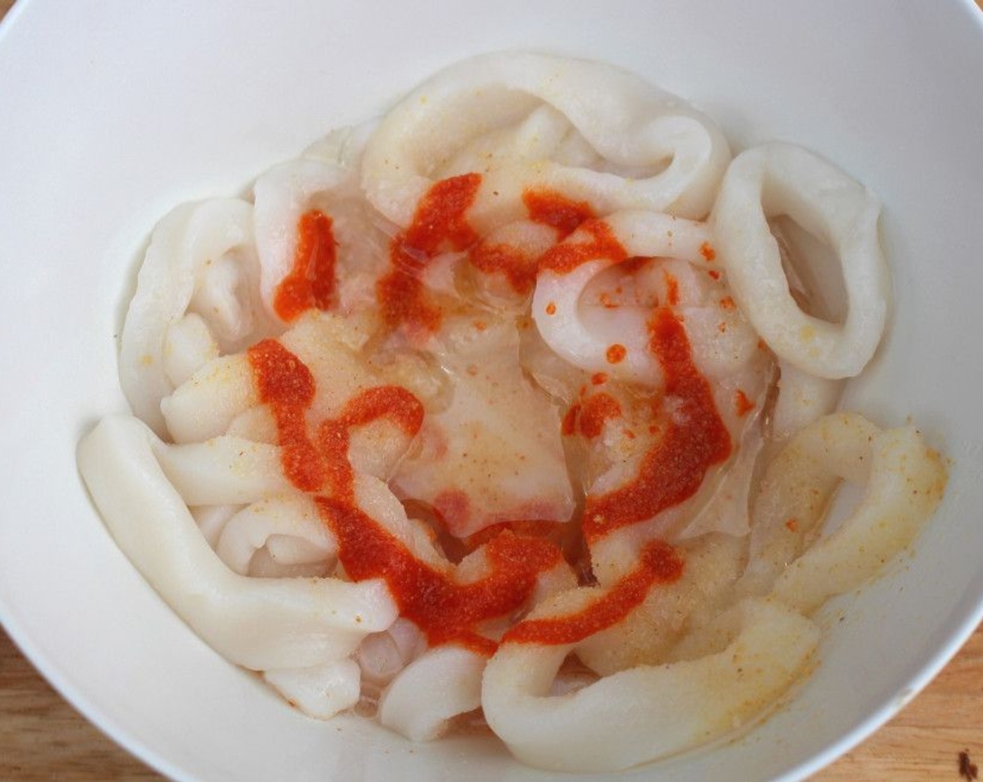 step 1 Season Squid Rings (1 lb) with 1 Tbsp of juice from Lemon (1), Sriracha (to taste), Granulated Garlic (to taste), Kosher Salt (to taste).