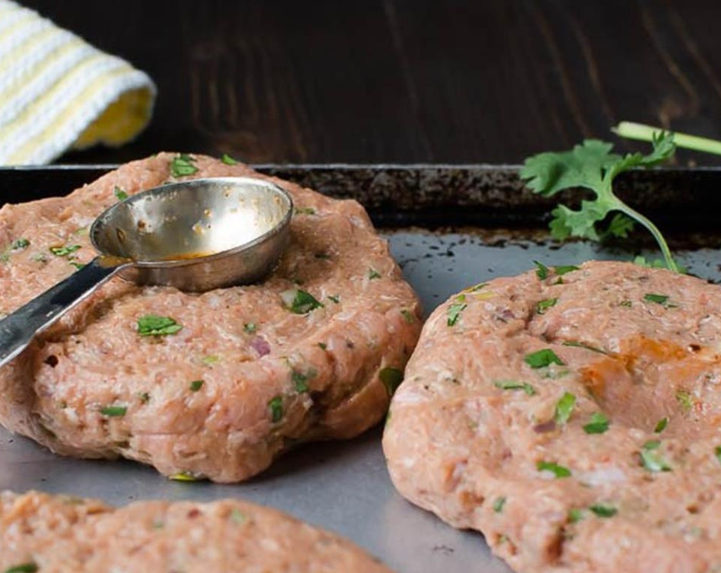 step 3 Form the burgers into 5 equal patties and transfer to a sheet pan. Use the rounded part of a tablespoon to make an indentation in the center of each burger (to prevent the puffy dome from forming as they cook).