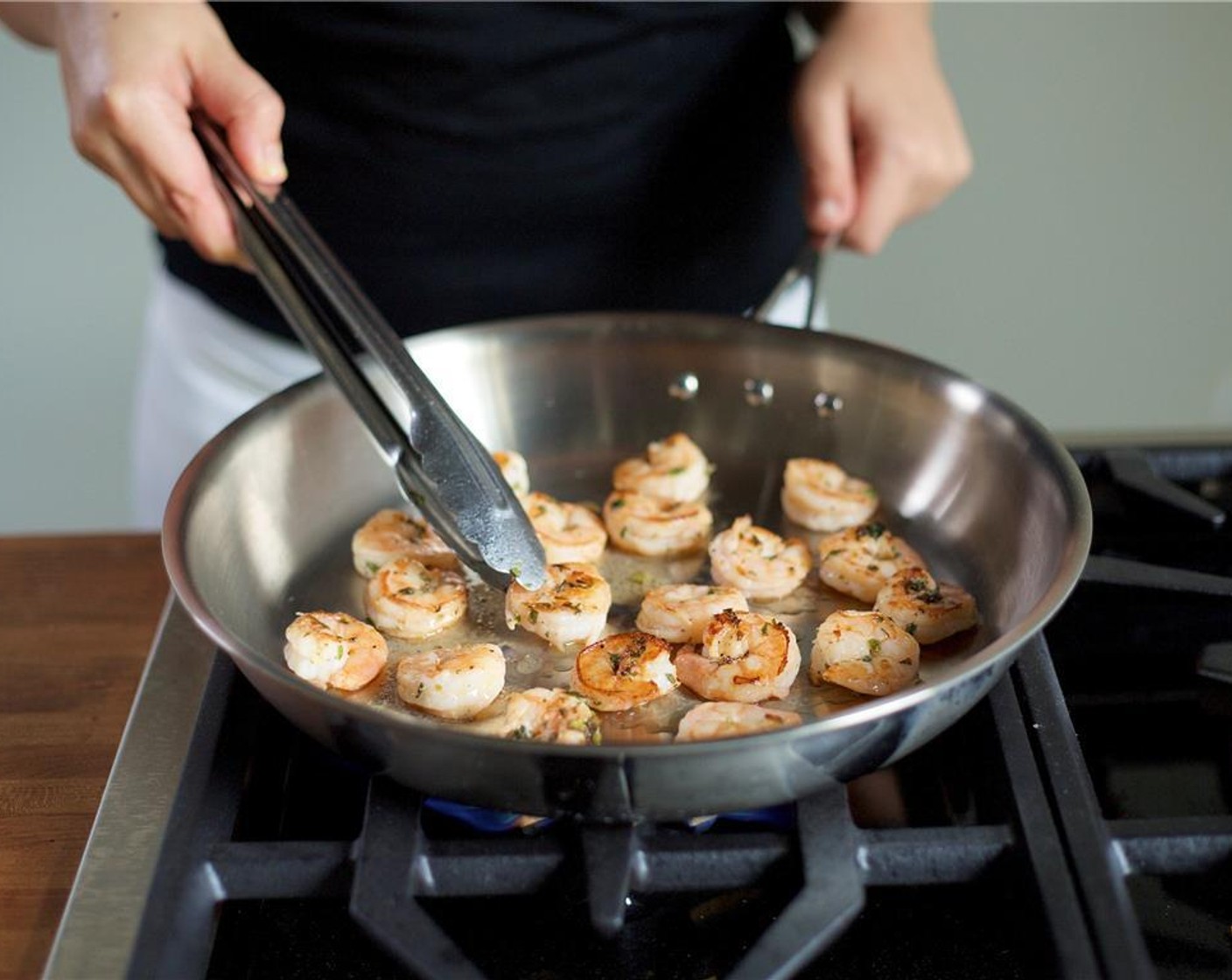 step 8 In a large pan over medium high heat, add Olive Oil (1 Tbsp) to the bottom of the pan and swirl pan to evenly coat bottom. When hot, carefully add shrimp in a single layer and cook on each side for two minutes. Remove from heat and set aside.