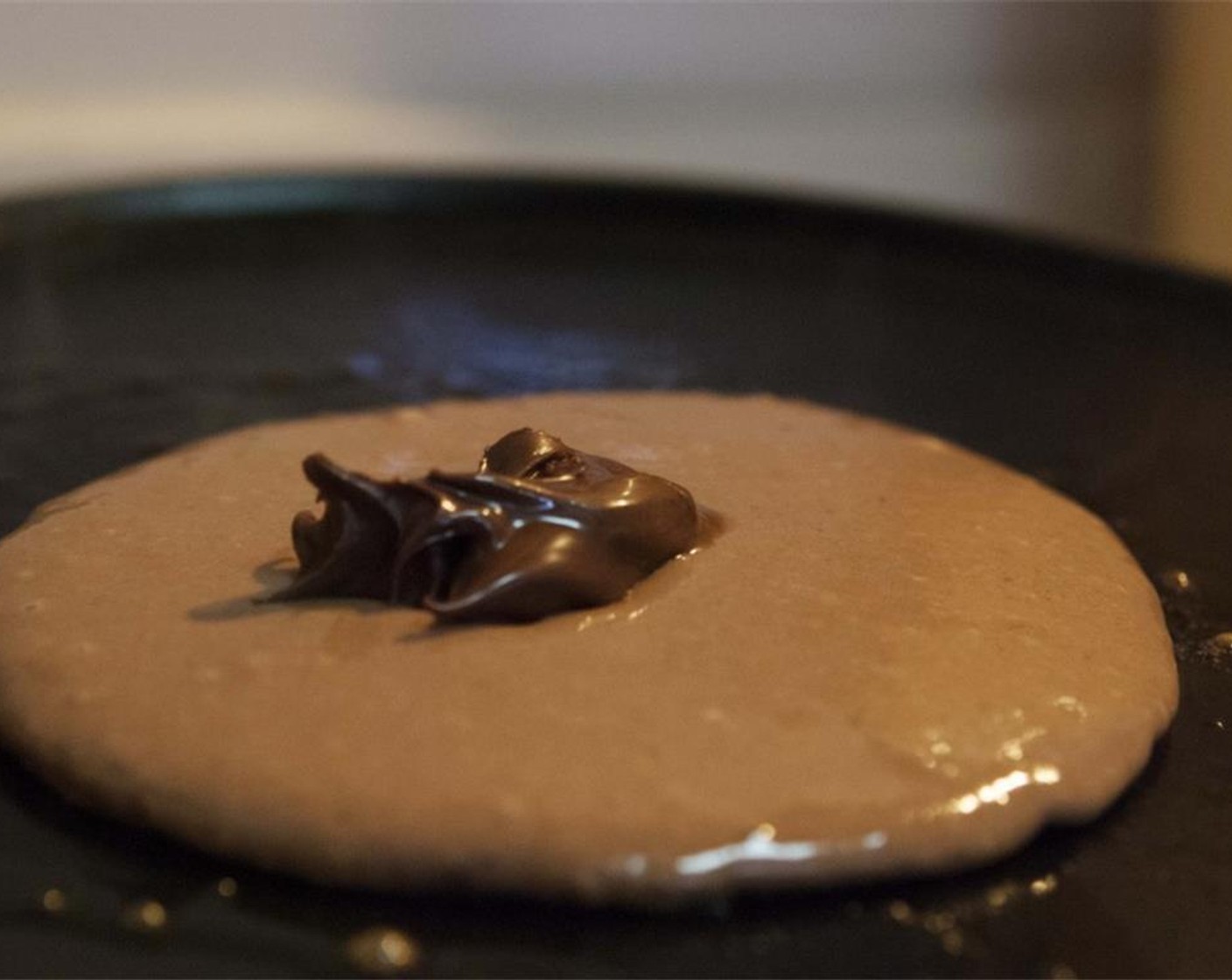 step 6 Use a 1/4 cup scoop to pour batter on the heated griddle. Spread out the pancake batter quickly and immediately scoop a large teaspoon of the Nutella® (1 1/2 Tbsp) into the middle of the raw pancake.