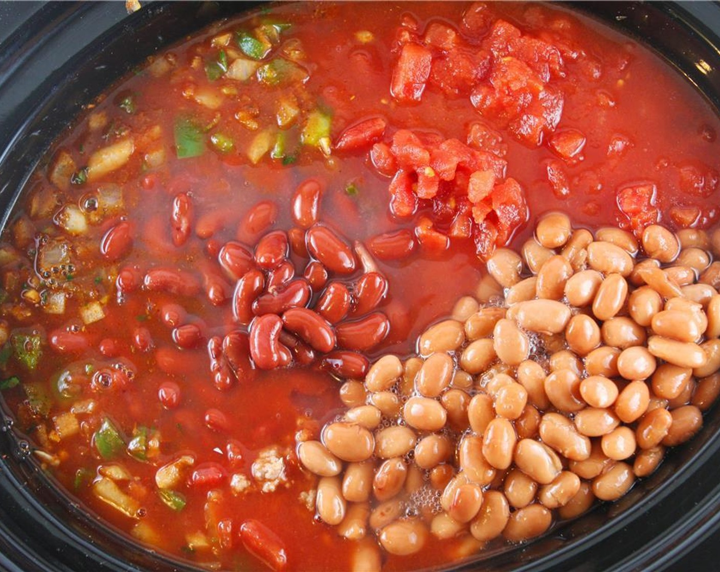 step 4 If cooking on the stovetop, add the cooked meat back to the skillet. If using a slow cooker, add meat-veggie mixture to the slow cooker. Add the Tomato Juice (46 fl oz), Canned Diced Tomatoes (3 1/2 cups), Tomato Sauce (1 3/4 cups), Canned Red Kidney Beans (2 1/2 cups) and Canned Pinto Beans (2 1/3 cups) to either the skillet or slow cooker, depending on which you are using.