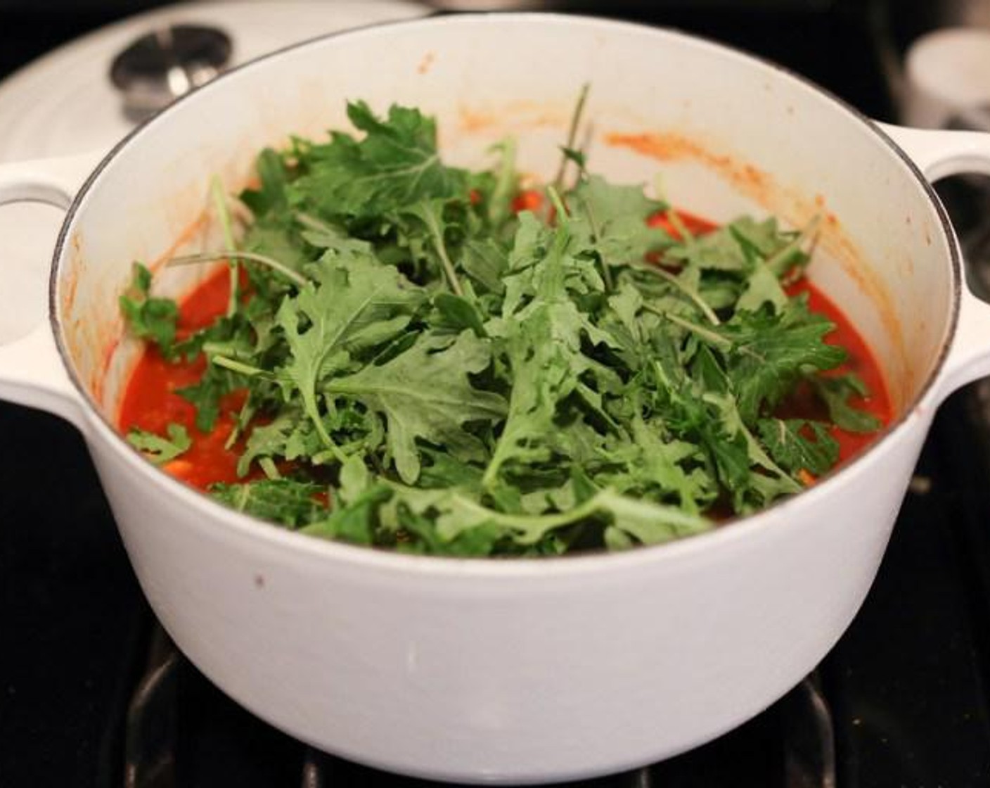 step 5 Stir in the Baby Kale (4 cups) or spinach and the Lime (1/2) and cook just until the greens have wilted. Taste and season with extra salt if necessary. Ladle the stew into bowls, garnish with Goat Cheese (4 Tbsp), Fresh Cilantro (to taste), and Tortilla Chips (to taste).