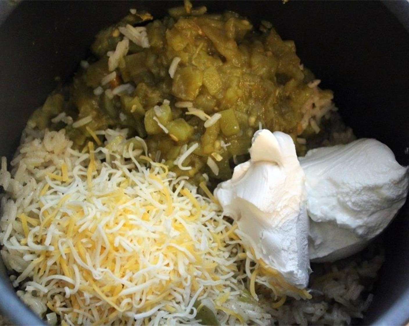 step 9 Now add the Diced Green Chiles (1 can), half the Shredded Cheese (1/2 cup), Sour Cream (4 Tbsp), and Cream Cheese (2 Tbsp) to the pot.