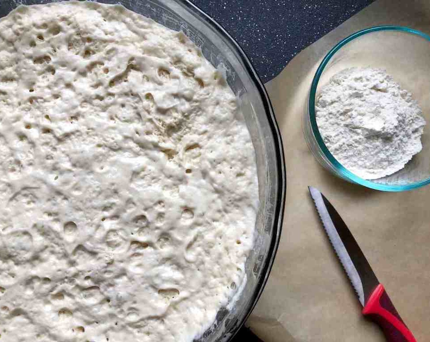 step 6 Once refrigerated, the dough will seem to have shrunk back upon itself as though it will never rise again. Cover your pizza peel with a piece of parchment paper.