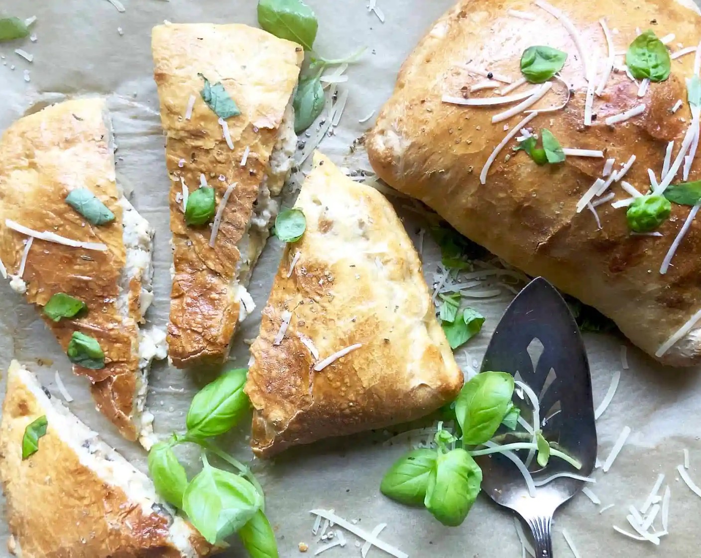 step 8 Transfer to a wire rack and allow to cool. Cut each calzone into four wedges. If desired, garnish with Fresh Basil (to taste) and Grated Parmesan Cheese (to taste).