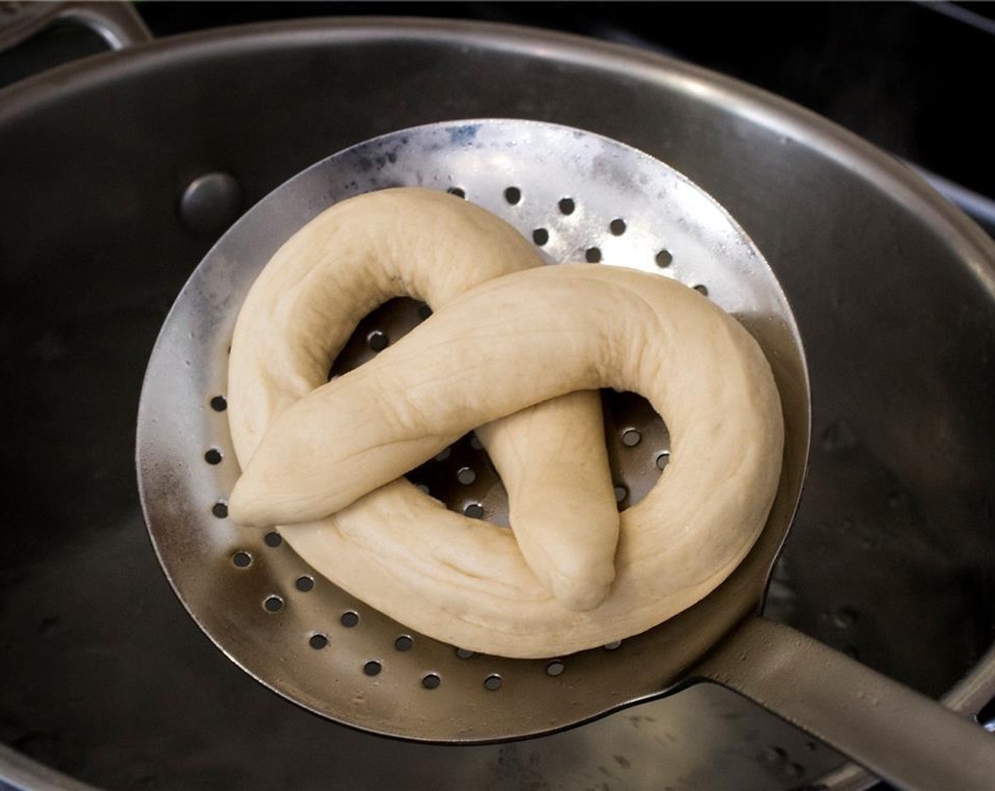 step 10 Transfer the pretzel to the parchment-lined baking sheet and cover with a damp tea towel while you work on the remaining pretzels.