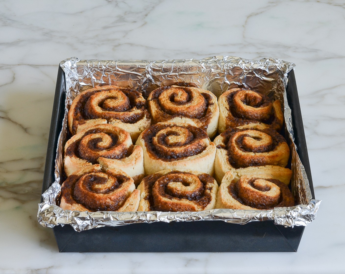 step 14 When the buns are done, use the foil overhang to lift them out of the baking pan and onto a wire rack. Let cool for 5 minutes, then carefully separate the buns, using a knife if necessary.