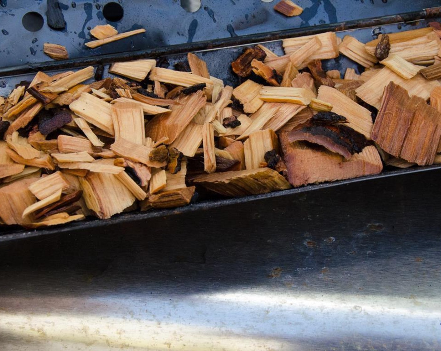 step 8 Add the chips to the smoker box and place over one of the burners. Preheat your gas grill with a closed lid and wait for a soft white smoke to begin emanating from the grill for about 10 to 15 minutes.