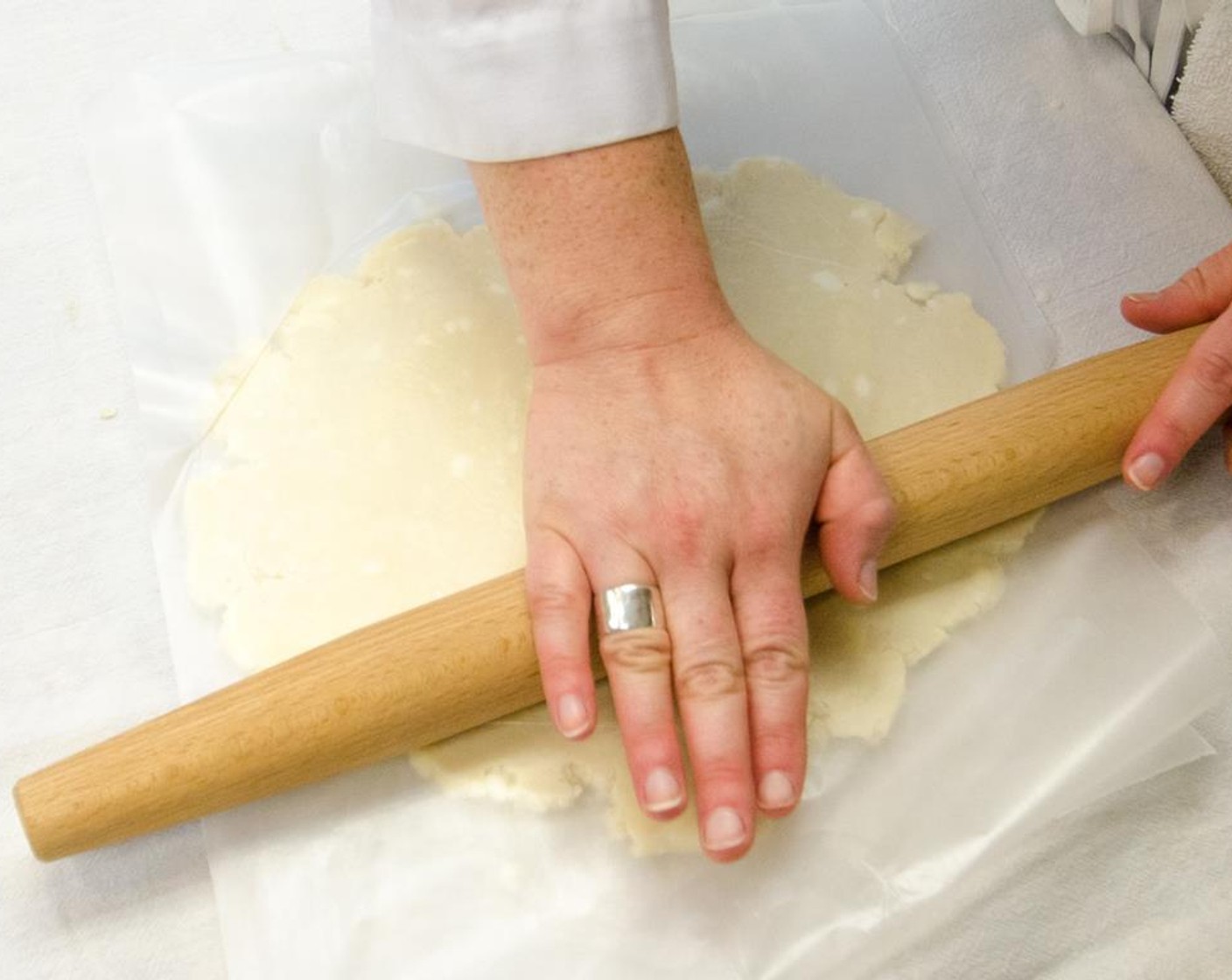 step 15 Remove one disk from the refrigerator. Place it between two pieces of plastic wrap, and roll out the bottom crust into a 12-inch circle.