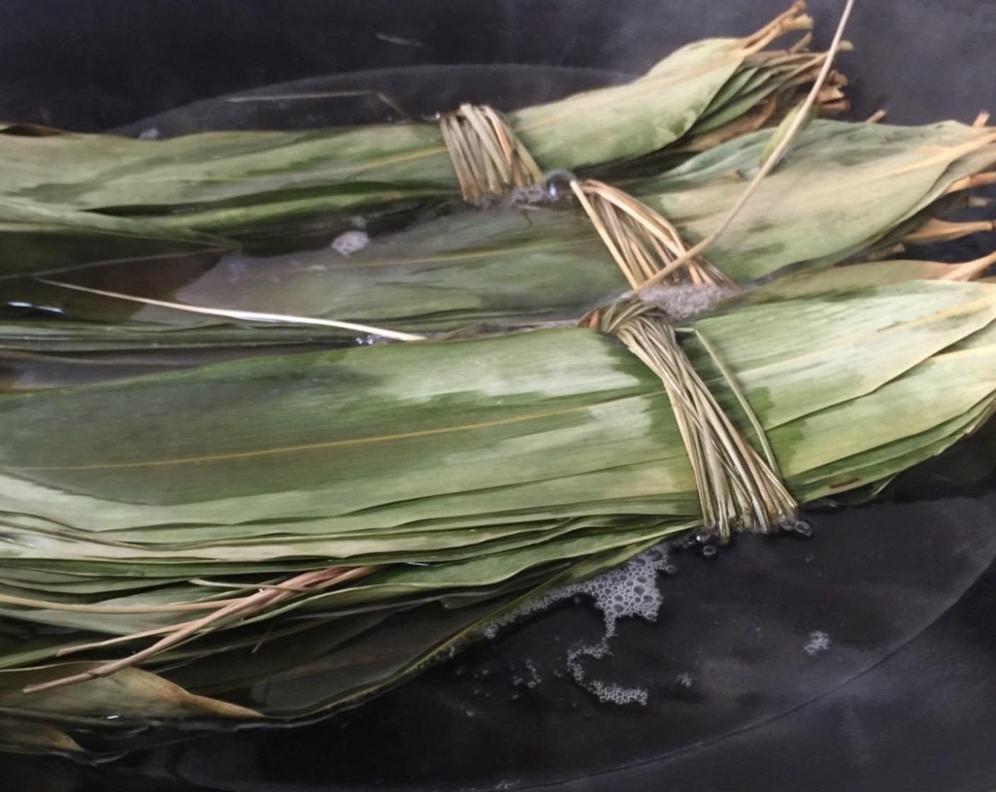 step 25 Carefully place the Bamboo Leaves (80 pieces) into the wok. Make sure the water covers all the leaves and cook over high heat for about 15 minutes, just to soften the bamboo leaves.