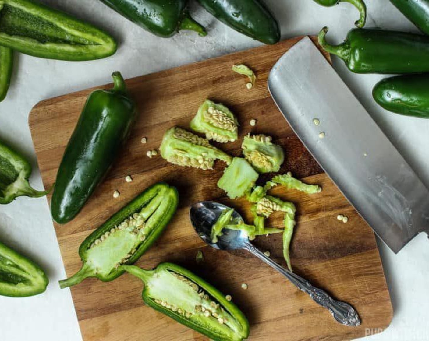 step 6 Using a spoon, jab into the whites of the jalapeno near the top around the stem and scrape downwards. Set aside the scraped out jalapenos.