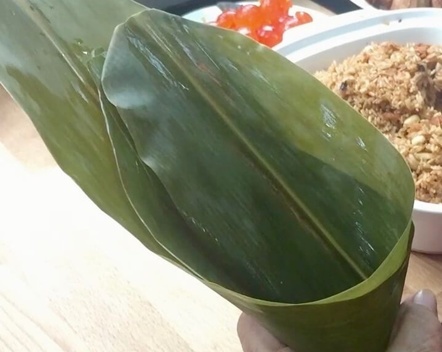 step 30 To wrap dumplings, layer two bamboo leaves in opposite directions, the tail end of one lining up with the top end of the other, with the smooth sides up and form a cone.