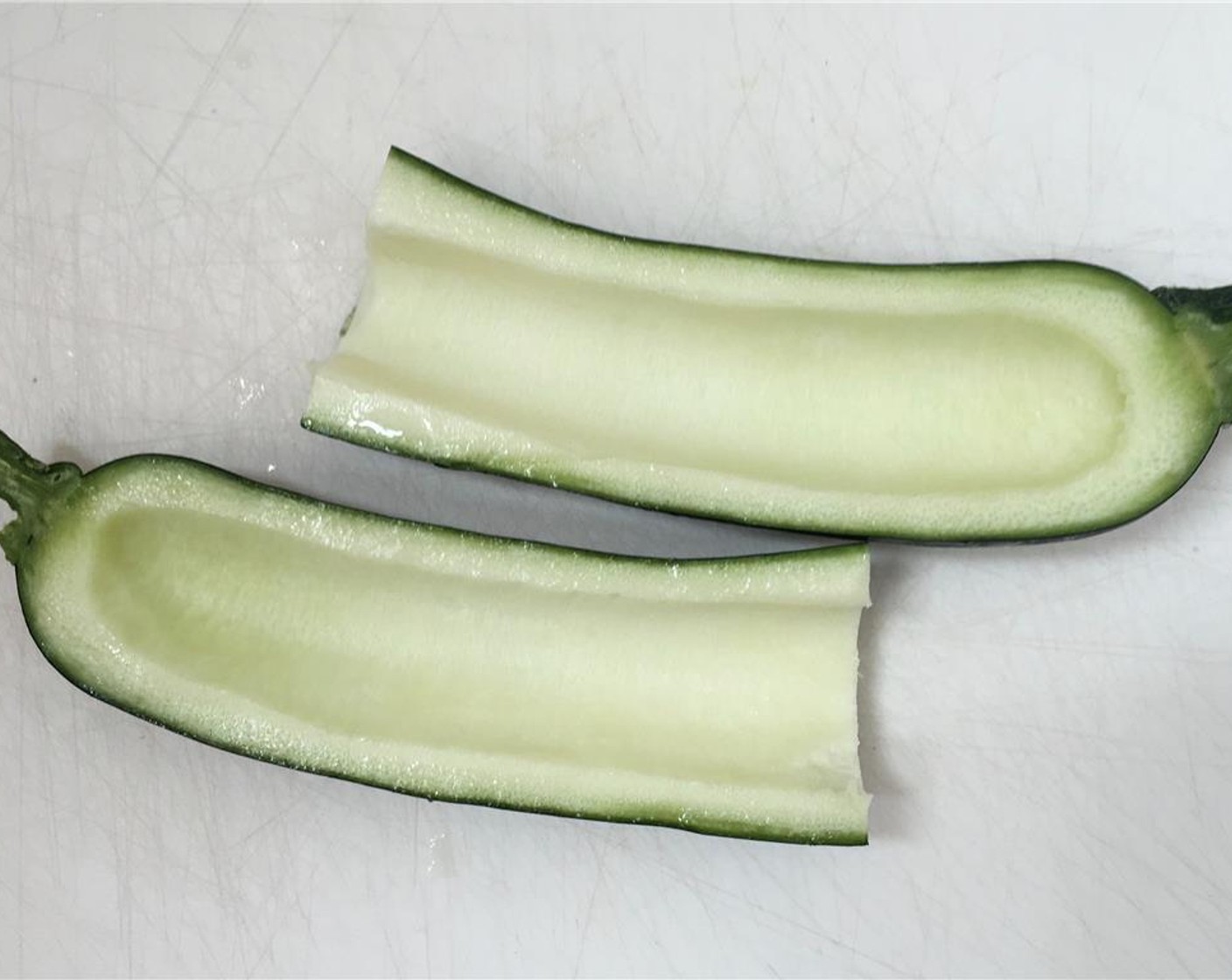 step 2 Slice the Zucchini (1) in half lengthwise. Remove the softer inside of the zucchini using a teaspoon.