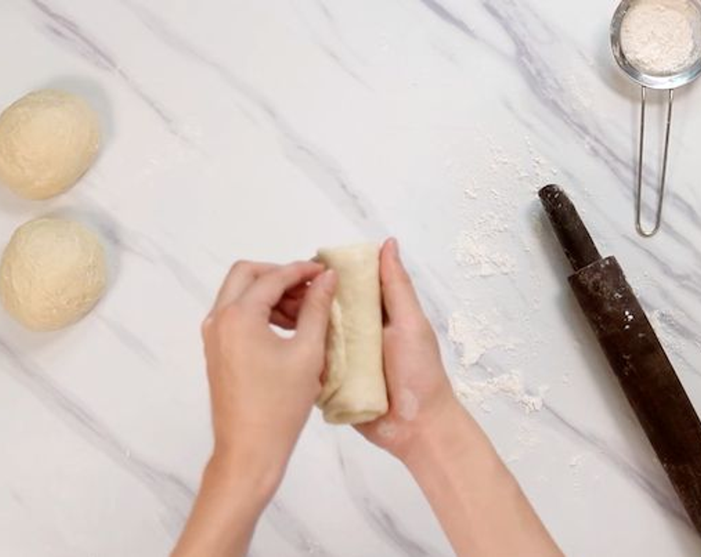 step 4 Divide the dough into 3 equal portions on a lightly floured surface. Roll each dough into a small disk, then tuck in both sides and roll into a long rectangular shape. Arrange the sides of the dough neatly then roll it up. Make sure to seal the edges and set it aside. Repeat this until all 3 portions are done.