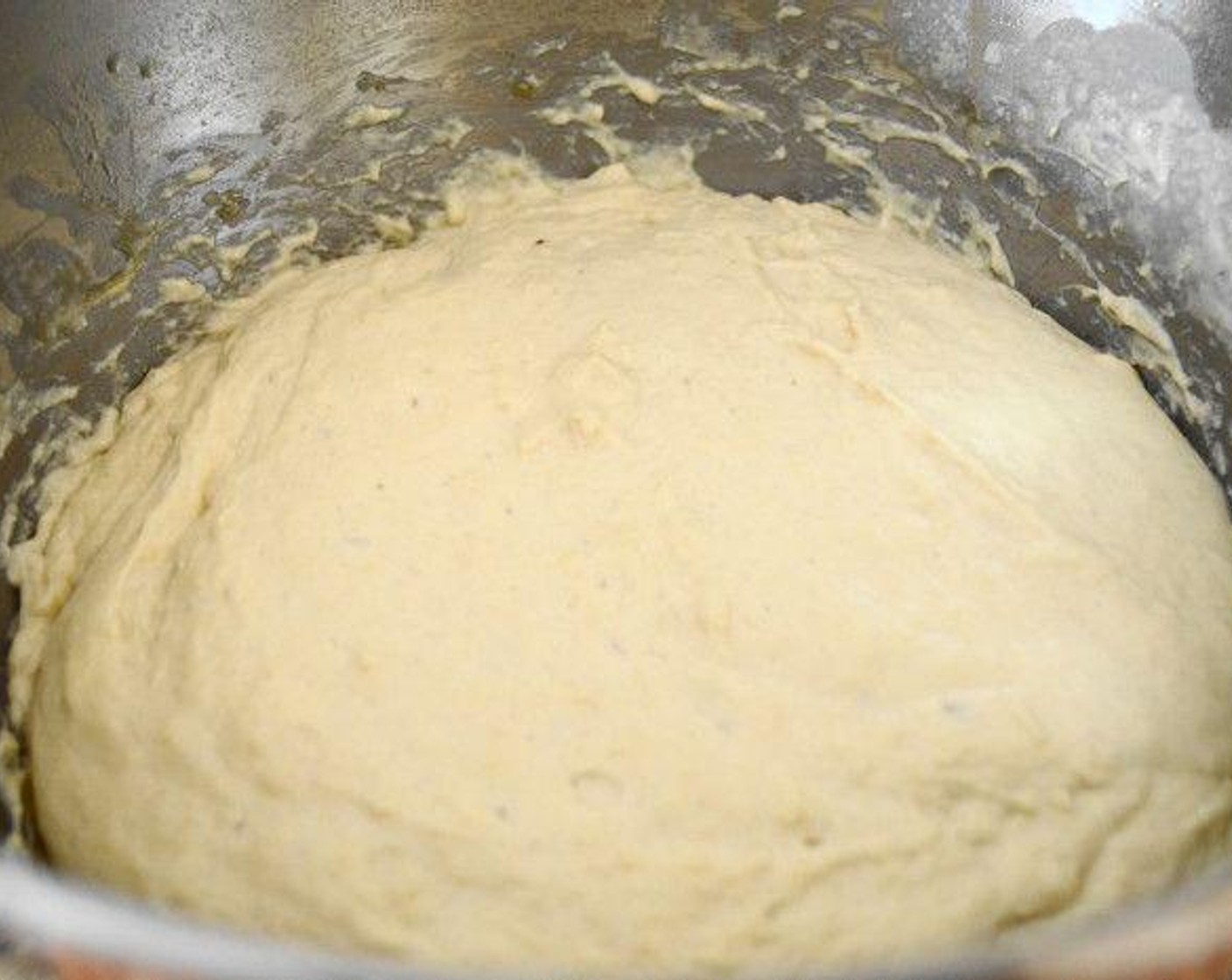 step 2 Slowly pour those wet ingredients into the stand mixer bowl of dry ingredients with the dough hook running until a sticky dough forms. Cover the stand mixer bowl with plastic wrap and let the bread dough double in size for about an hour in a warm area of the kitchen.