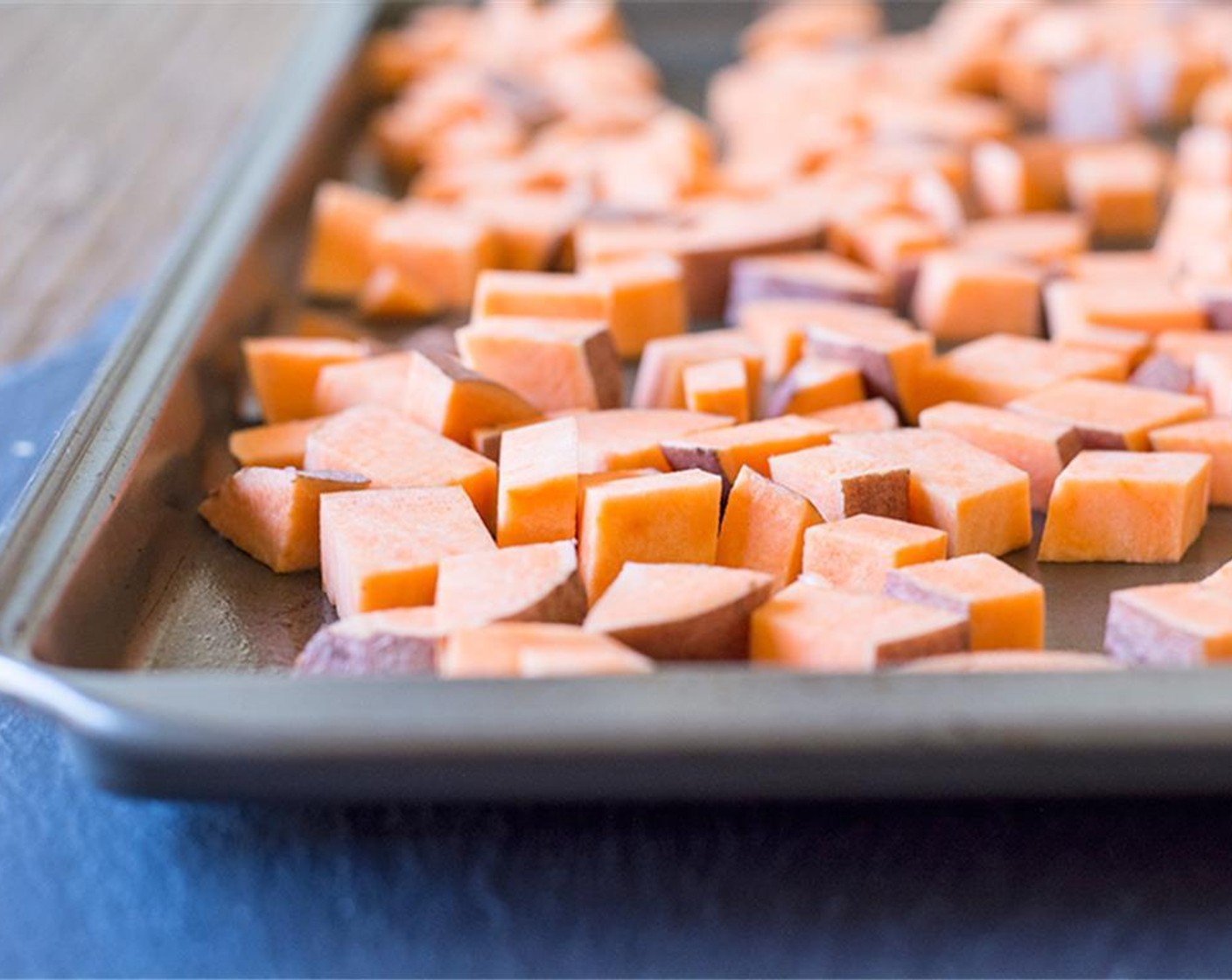 step 3 Spread Sweet Potatoes (2) on one pan in a single layer and spray with Coconut Oil Cooking Spray (as needed).