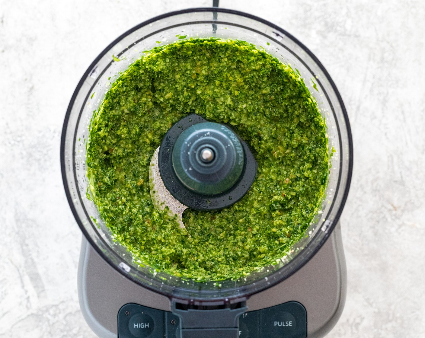 step 2 Turn the food processor to low speed. As it's running, slowly drizzle in Extra-Virgin Olive Oil (1/2 cup) until smooth with some smaller pieces remaining, about 10 seconds from start to finish. Season to taste with salt. Transfer pesto to a small bowl and set aside.