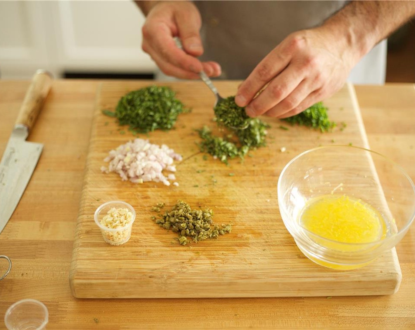 step 13 Meanwhile, finely chop Fresh Mint (1/2 cup), Fresh Oregano (1/2 cup), Capers (1 Tbsp), Fresh Chives (6 stalks), and add to lemon shallot mixture.