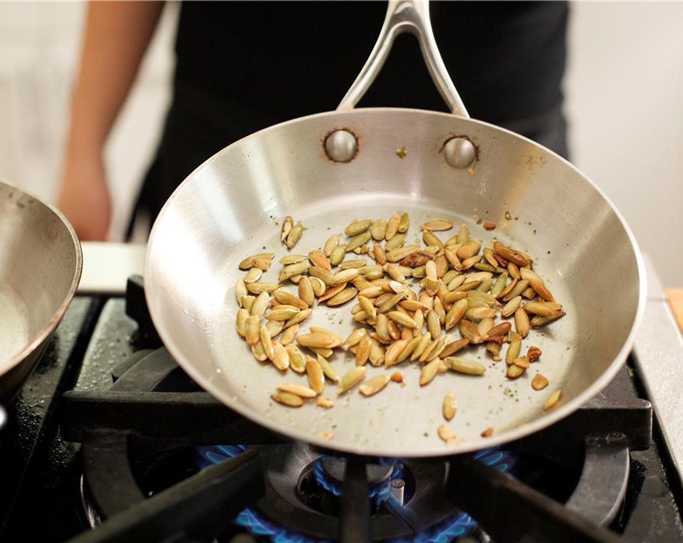 step 11 While the parsnips roast, place a small saute pan over medium high heat. Add Olive Oil (1/2 tsp). When hot, add the Pumpkin Seeds (2 Tbsp), Salt (1/4 tsp), and Ground Black Pepper (1/4 tsp).