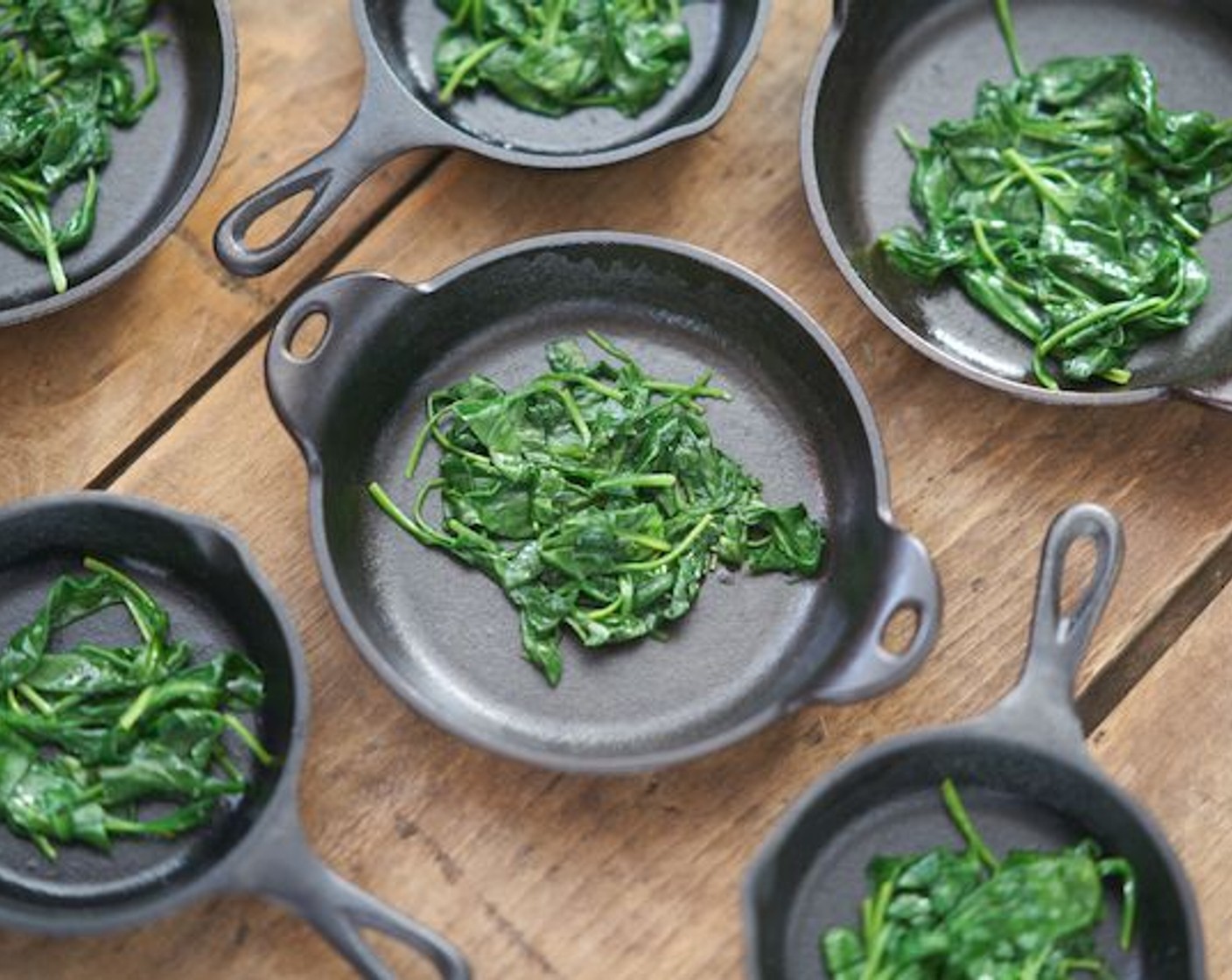 step 4 In a skillet over medium heat, melt Butter (1/2 Tbsp). Sauté Fresh Baby Spinach (5 2/3 cups) until just wilted. Distribute evenly among oven-safe cooking/serving dishes.
