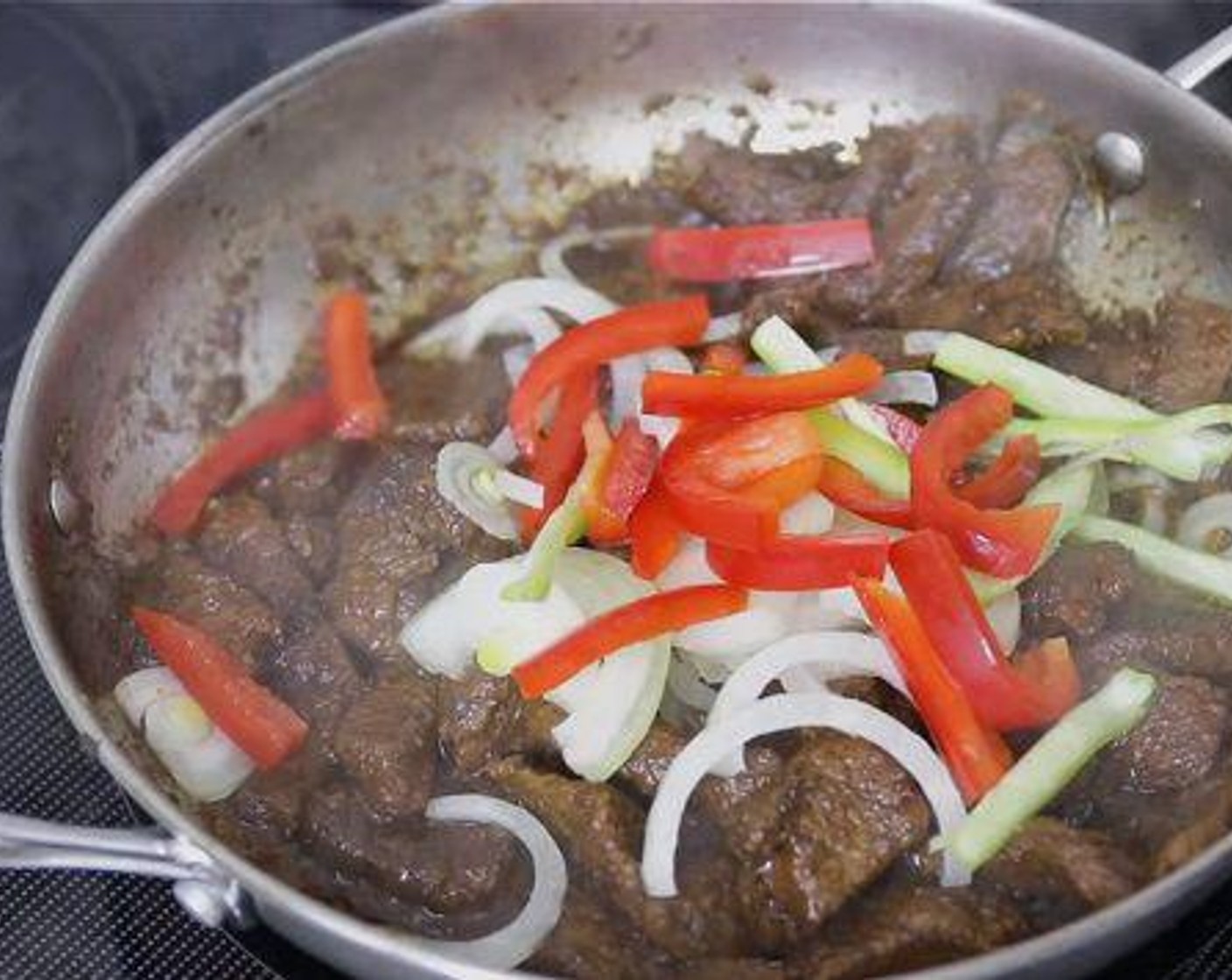 step 11 Once the beef is tender, add onion, cubanelle pepper and red bell pepper and stir to combine. Add Tomato Paste (1/4 cup) and enough water to make a stew-like gravy consistency, then stir to blend everything well. Cover and cook for 3-5 minutes.