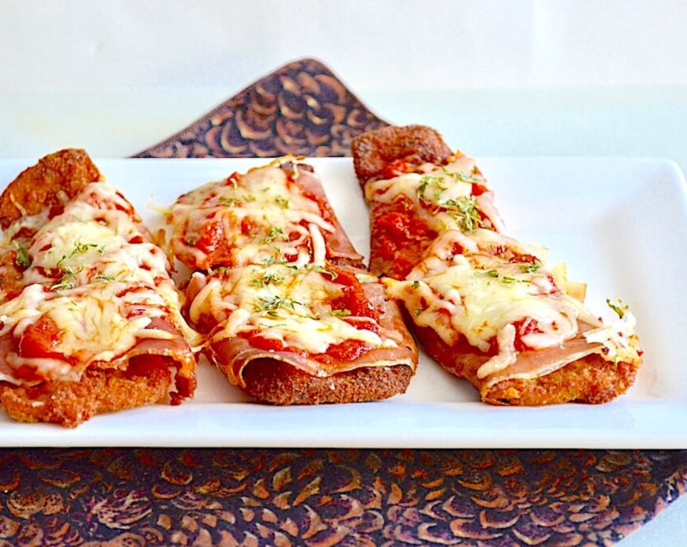 step 8 Bake it all for 10-15 minutes, until the cheese is bubbly and the prosciutto gets crispy. Serve immediately! You can serve it on crusty bread for an eggplant parmigiana sandwich or over pasta with more warmed up marinara. Enjoy!