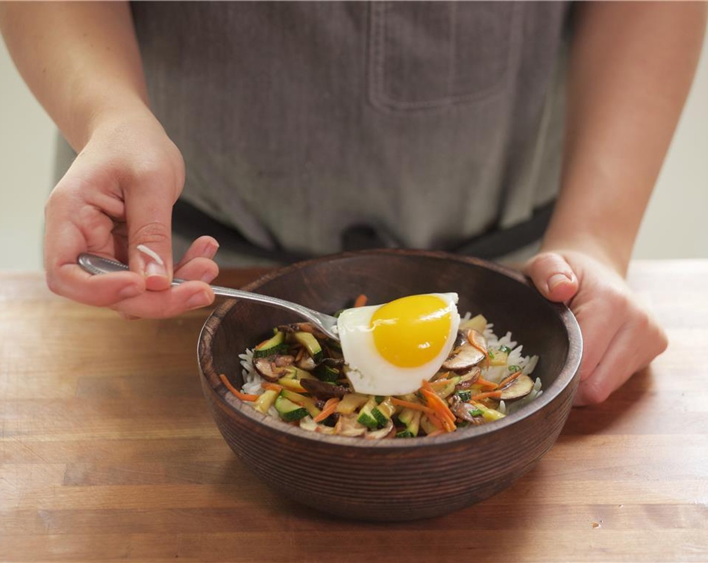 step 10 In the center of two bowls, place the rice mixture. Place the vegetable mixture on top. Set fried egg directly on top.