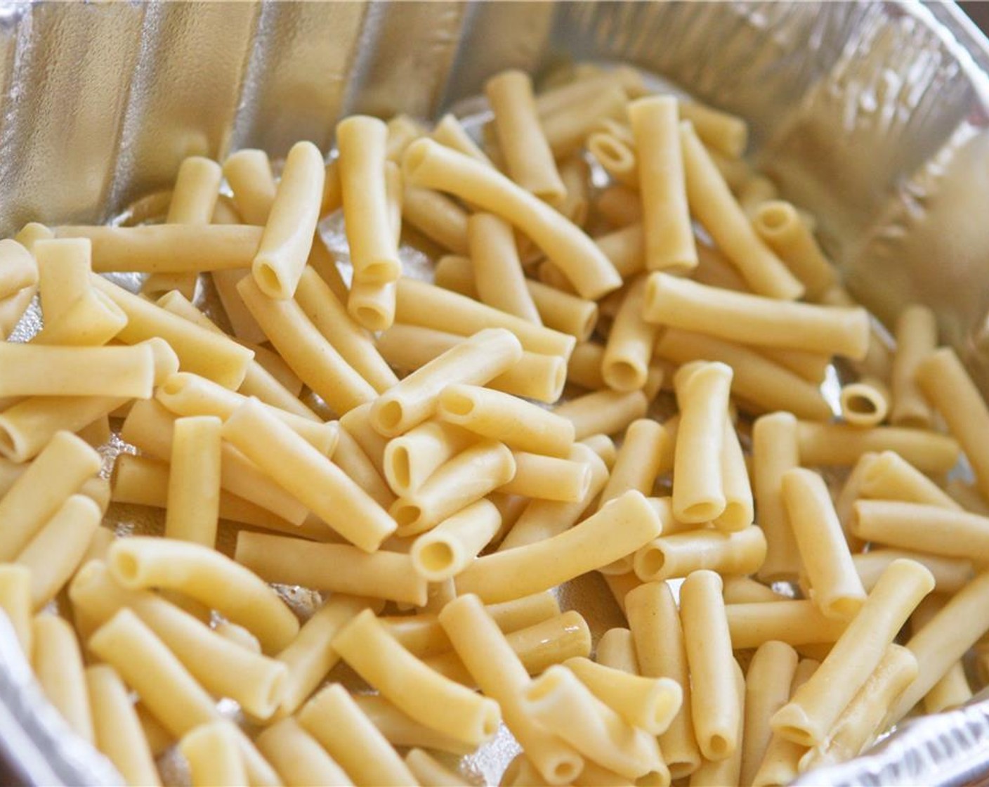 step 5 Begin to make layers inside the baking dish. First, use half of the cooked ziti.