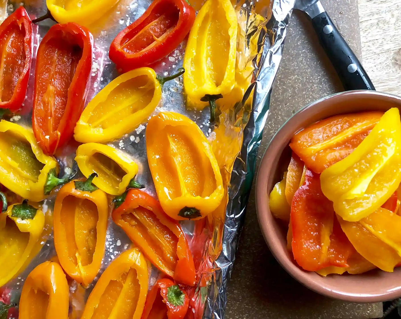step 5 Using the same foil-lined baking sheet, flip over each pepper so that the charred side is on the bottom. Cut and remove the top third of each pepper from stem end to tip.
